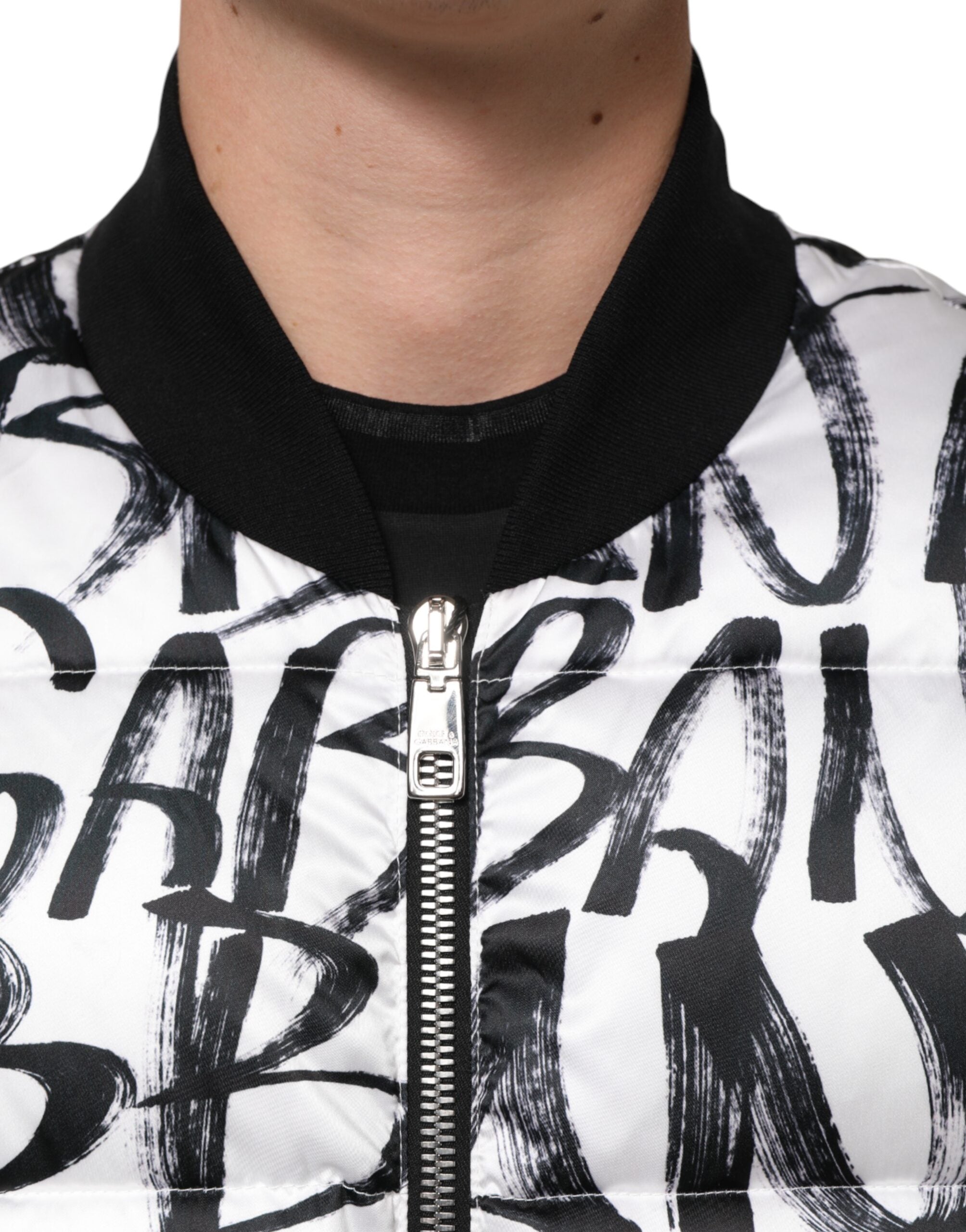 Veste bomber matelassée Dolce & Gabbana blanche et noire avec logo graffiti, style tendance et moderne.