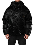 Veste matelassée noire à capuche avec logo Dolce & Gabbana et fermeture éclair complète, vue de face.