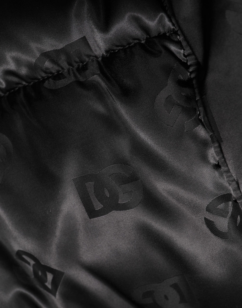 Veste matelassée noire Dolce & Gabbana avec logo monogramme, capuche en nylon, style puffer.