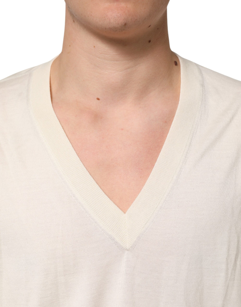 Pull homme Dolce & Gabbana en laine vierge ivoire à col en V, confectionné en maille fine, visible sur l'image.