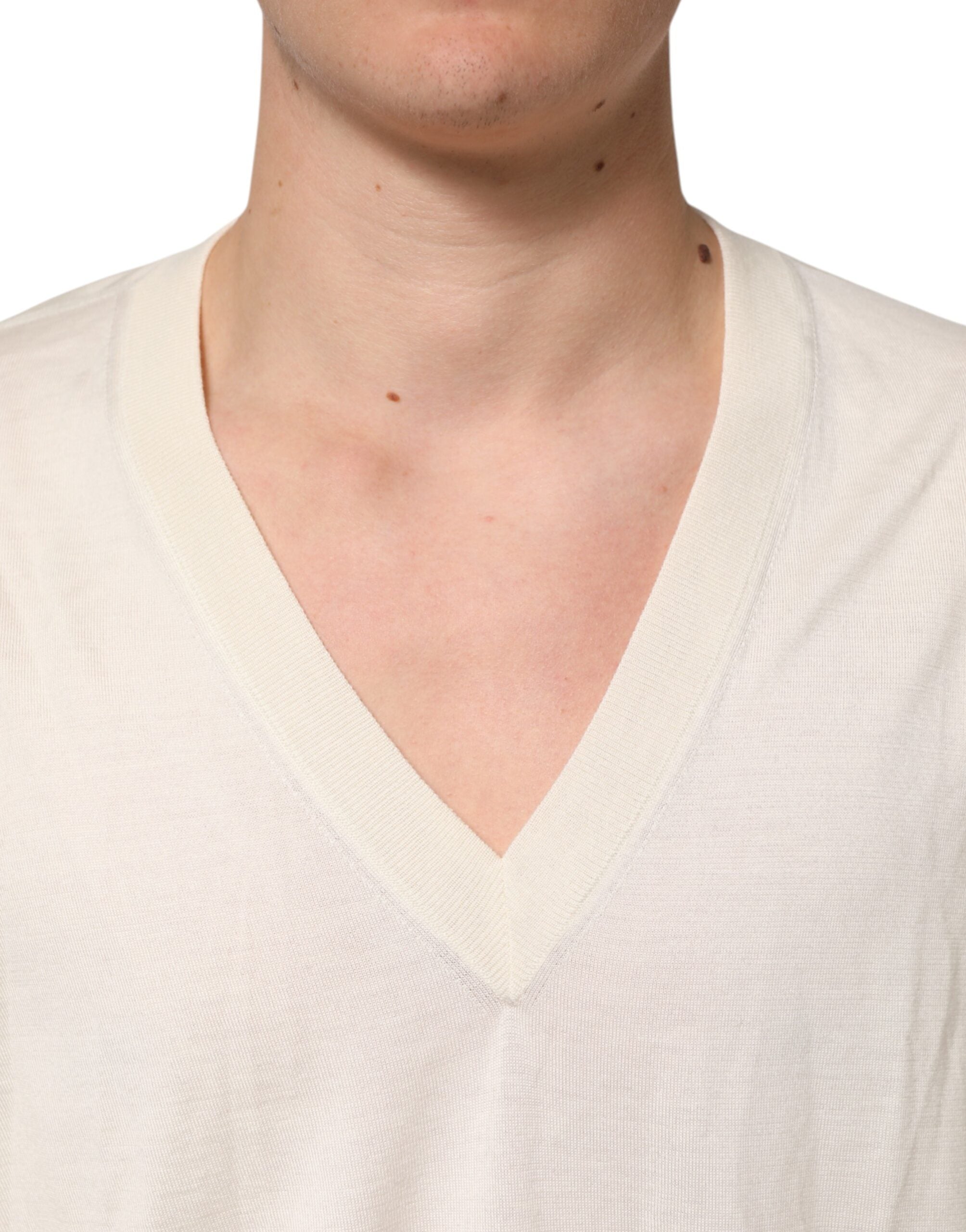 Pull homme Dolce & Gabbana en laine vierge ivoire à col en V, confectionné en maille fine, visible sur l'image.