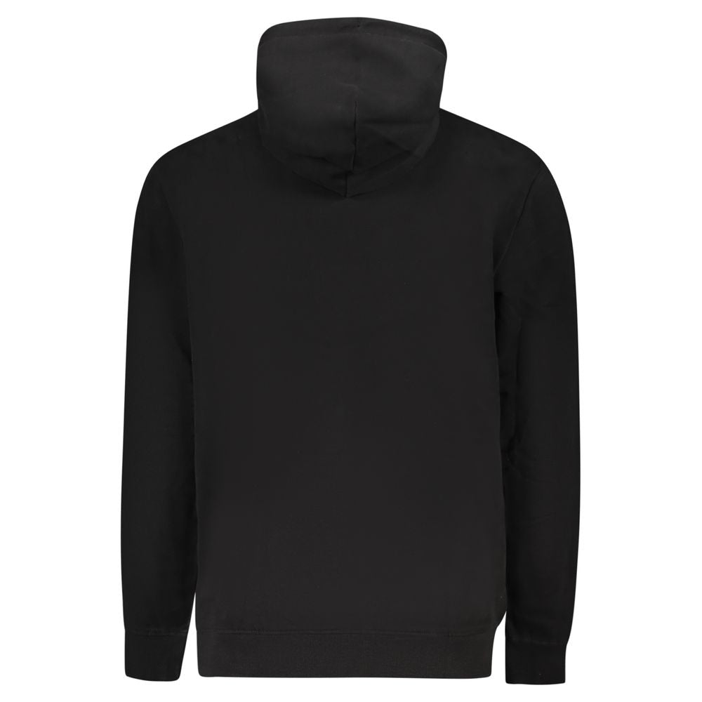 Sweat-shirt noir en coton pour homme de Tommy Hilfiger, avec logo discret sur la poitrine, porté sur un mannequin.