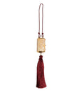 Sac à main Dolce & Gabbana blanc avec pendentif en perles de résine, métal doré et gland rouge.