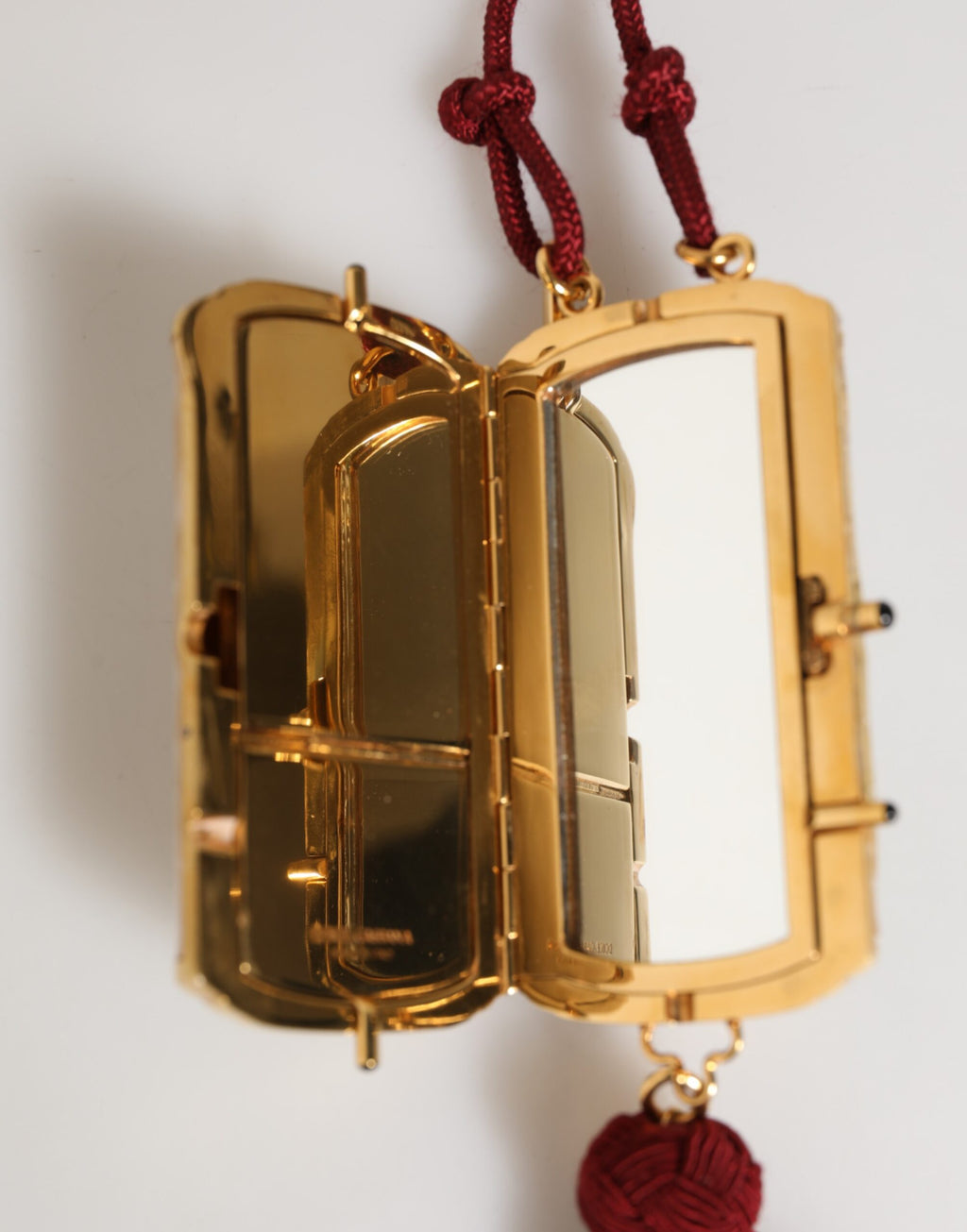 Mini sac à bandoulière Dolce & Gabbana en résine blanche avec pendentif en métal doré, style croix et sac compact élégant.