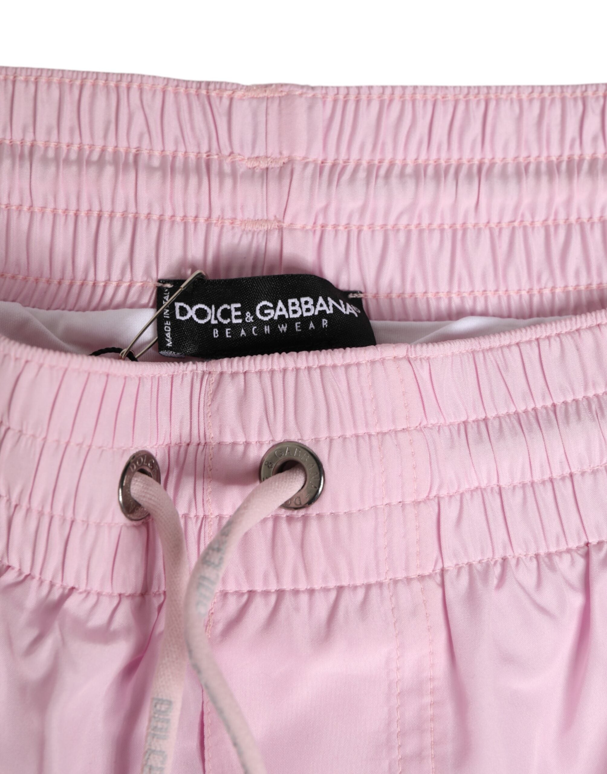 Maillot de bain homme Dolce & Gabbana en nylon rose avec logo et rayures latérales, parfait pour la plage.