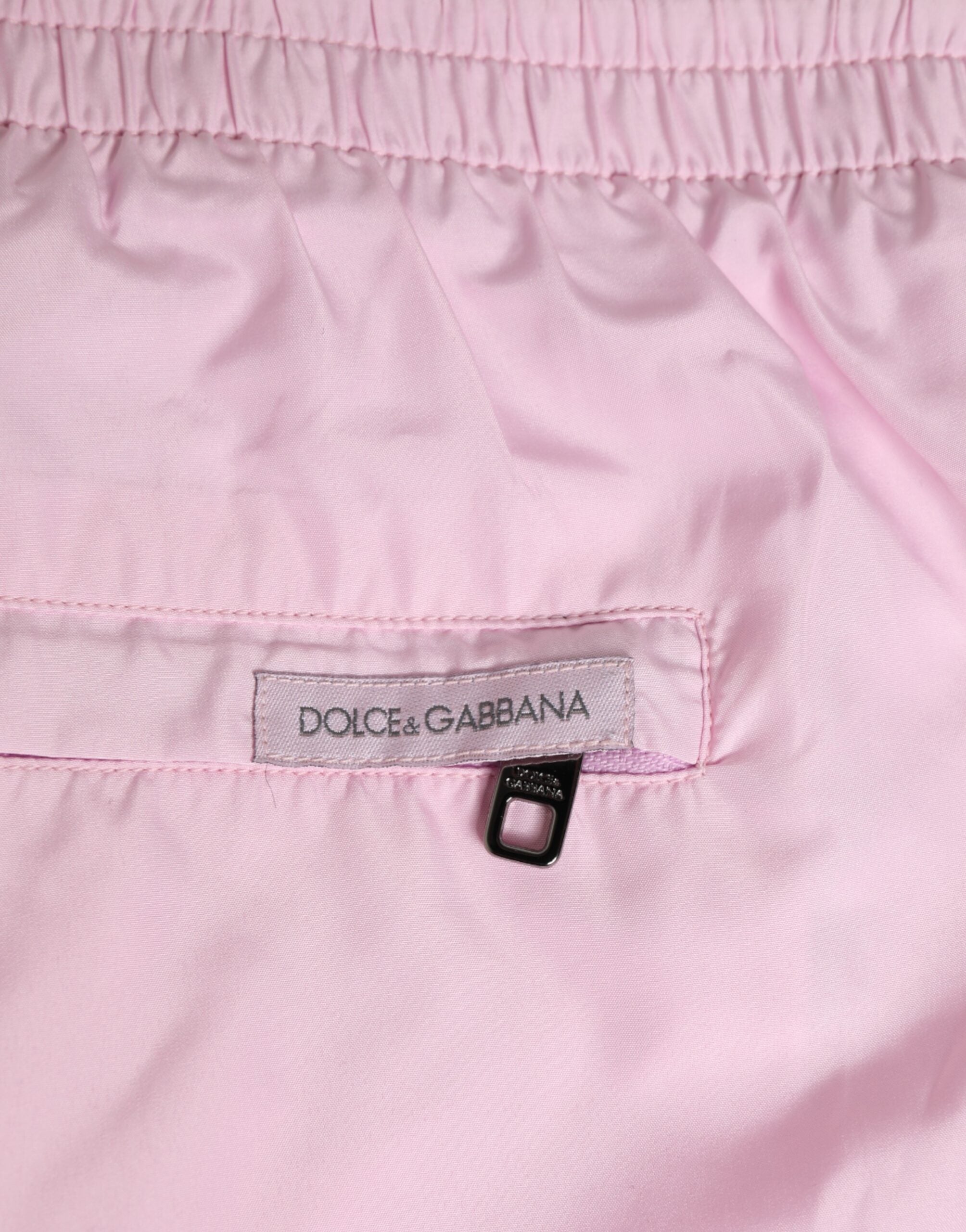 Maillot de bain homme Dolce & Gabbana en nylon rose avec logo et rayures latérales, idéal pour la plage.