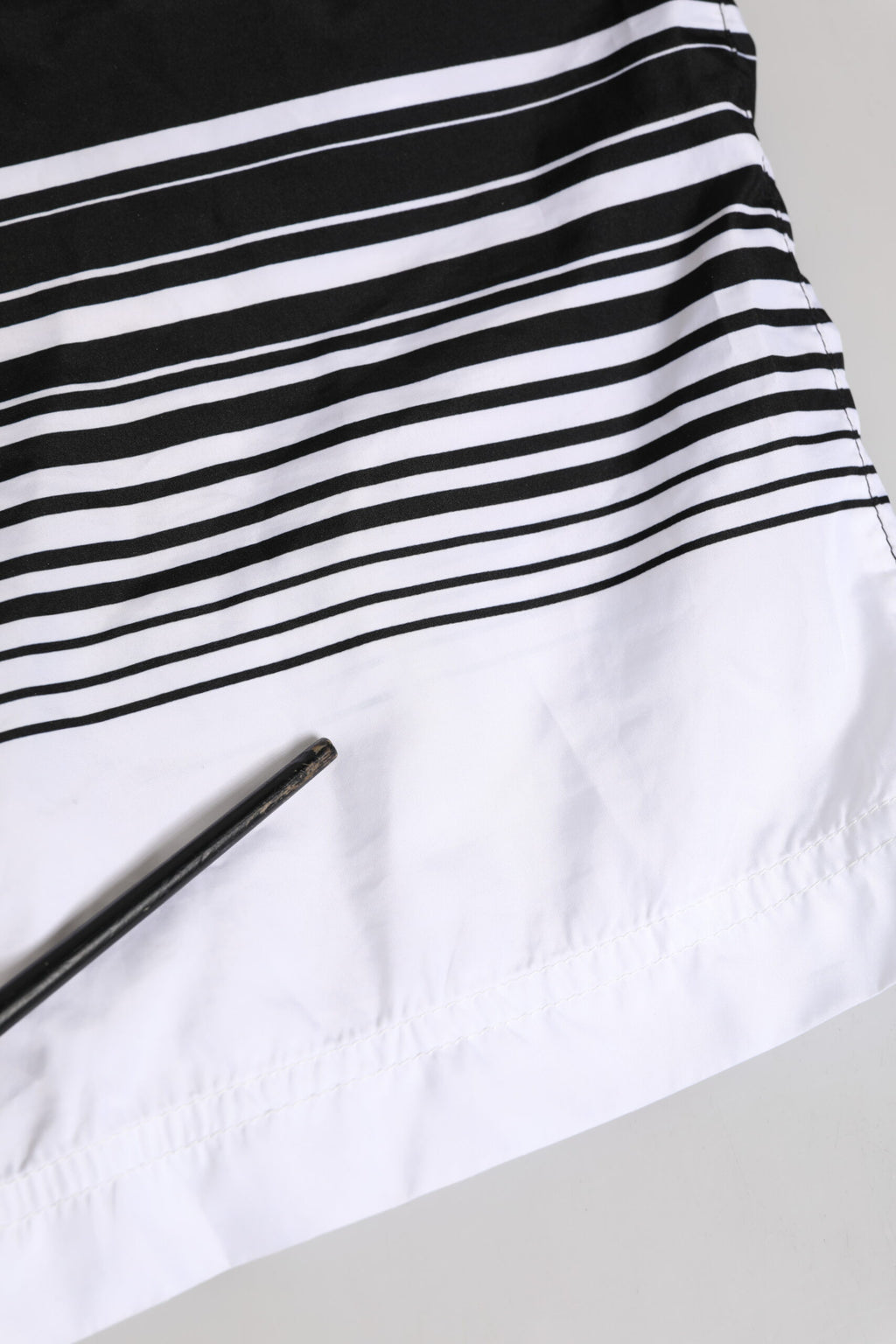 Maillot de bain homme Dolce & Gabbana noir et blanc avec rayures et logo DG, coupe courte, style élégant et moderne.