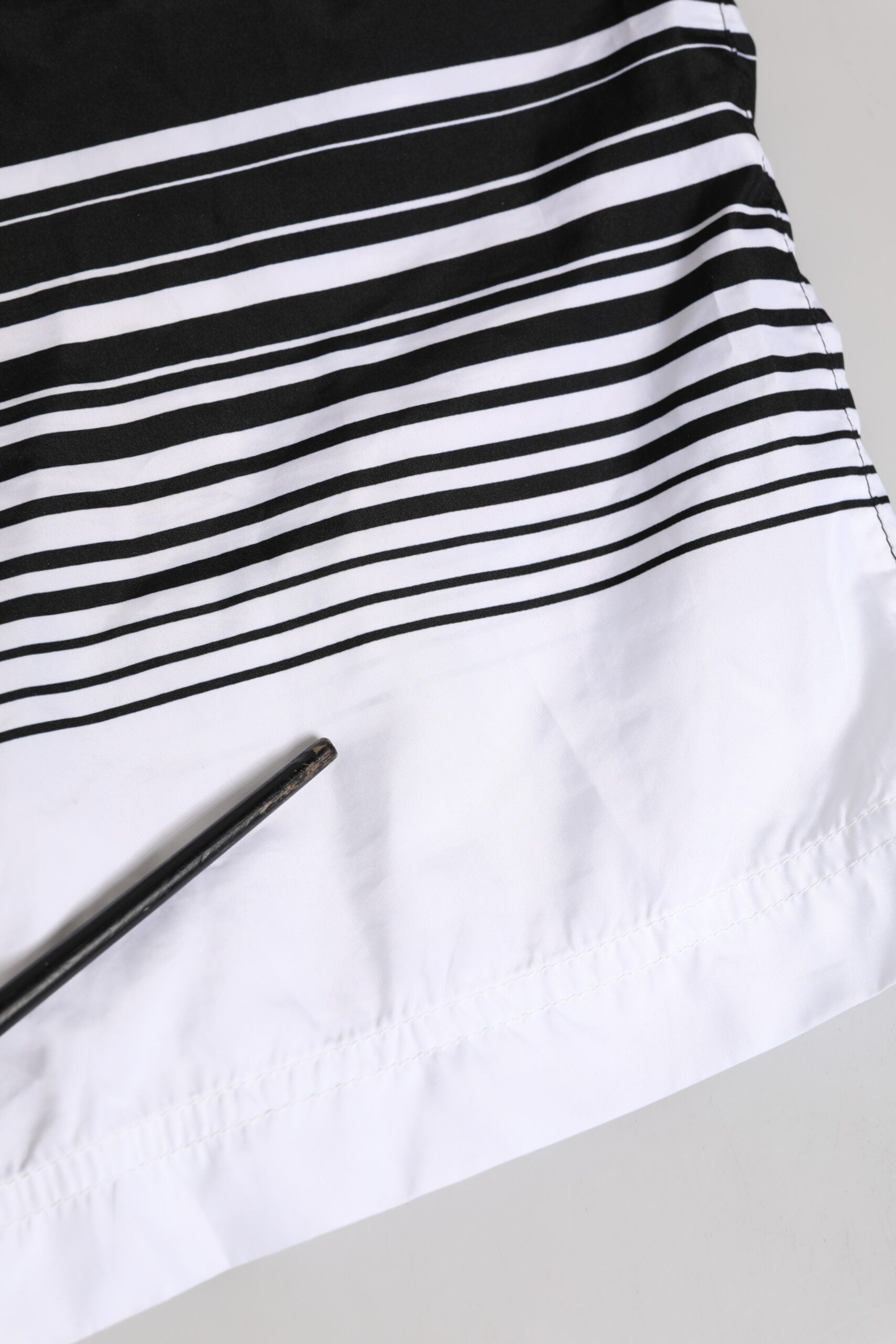 Maillot de bain homme Dolce & Gabbana noir et blanc avec rayures et logo DG, coupe courte, style élégant et moderne.