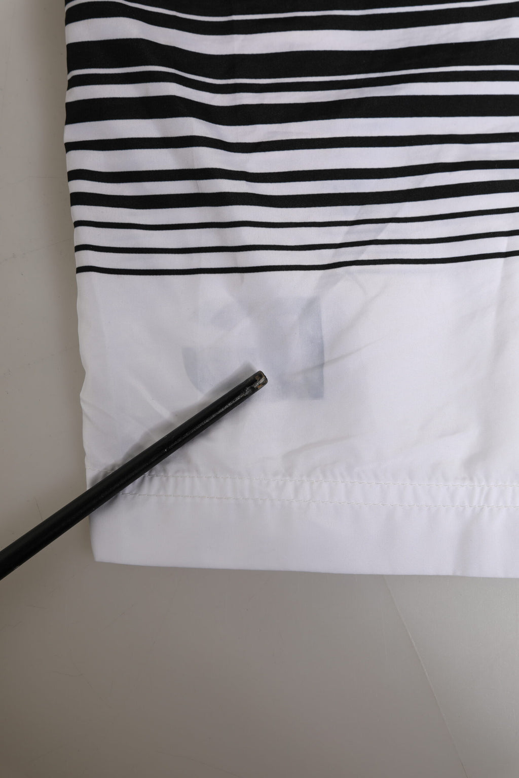 Short de bain homme Dolce & Gabbana noir et blanc avec rayures et logo DG, en tissu léger, pour la plage ou la piscine.