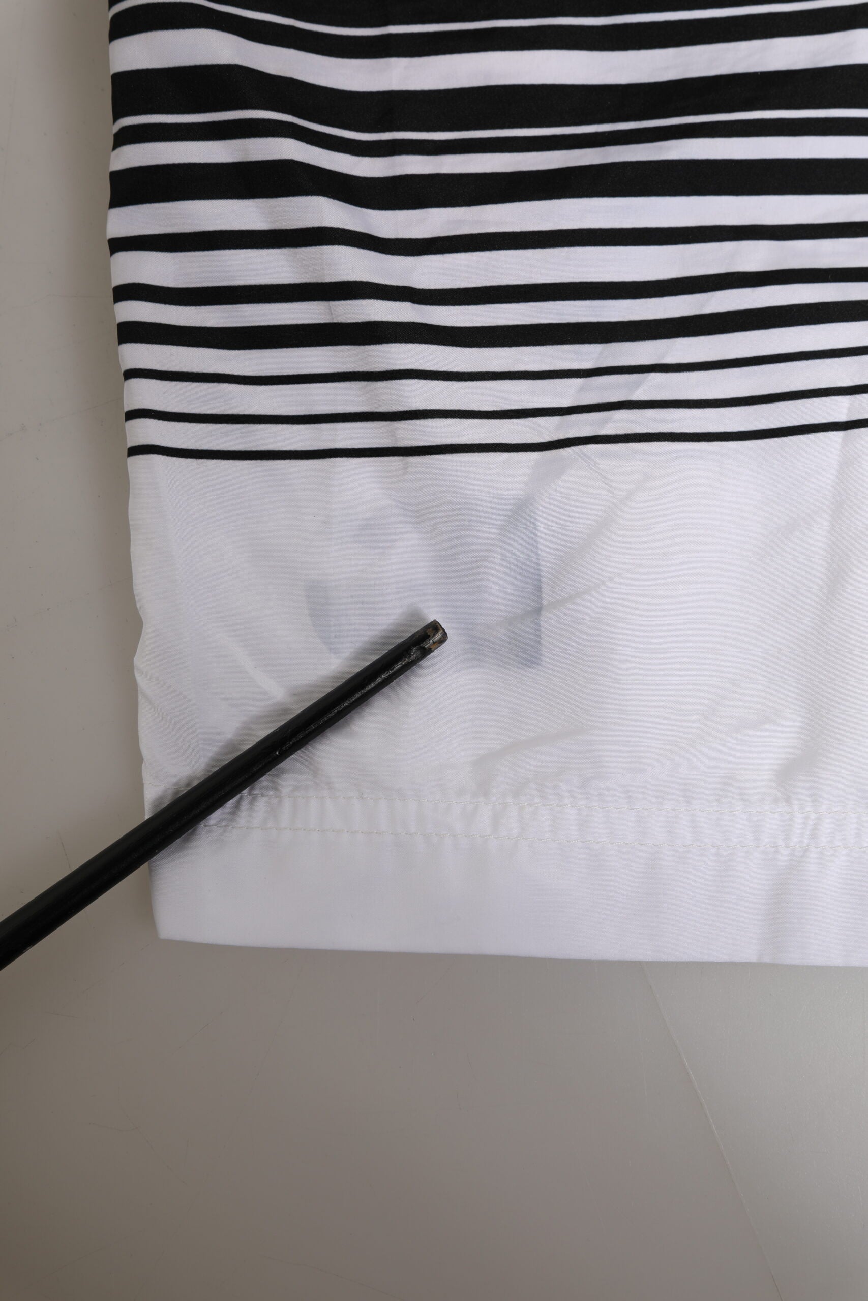 Short de bain homme Dolce & Gabbana noir et blanc avec rayures et logo DG, en tissu léger, pour la plage ou la piscine.