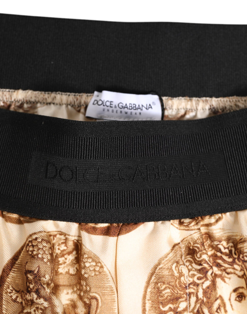 Shorts de bain en soie Dolce & Gabbana avec motif antique en pièces de monnaie brunes.