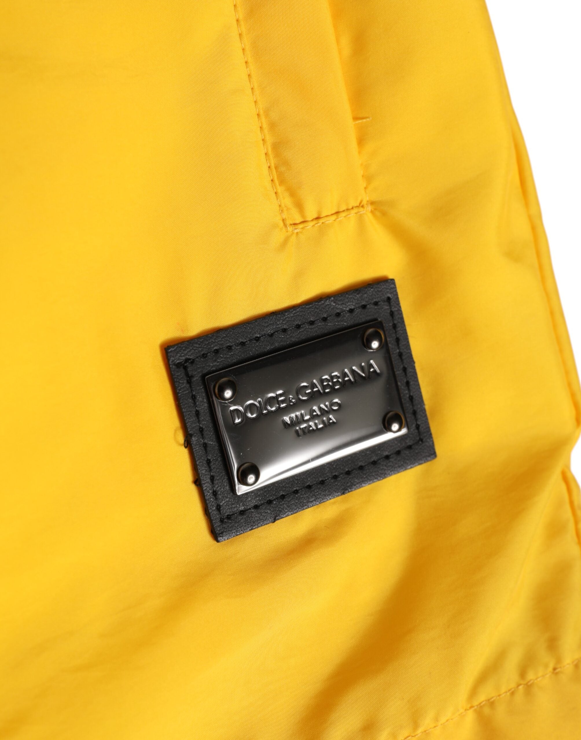 Shorts de bain Dolce & Gabbana en nylon jaune avec logo et plaque, style boxer, vue de face montrant le design.