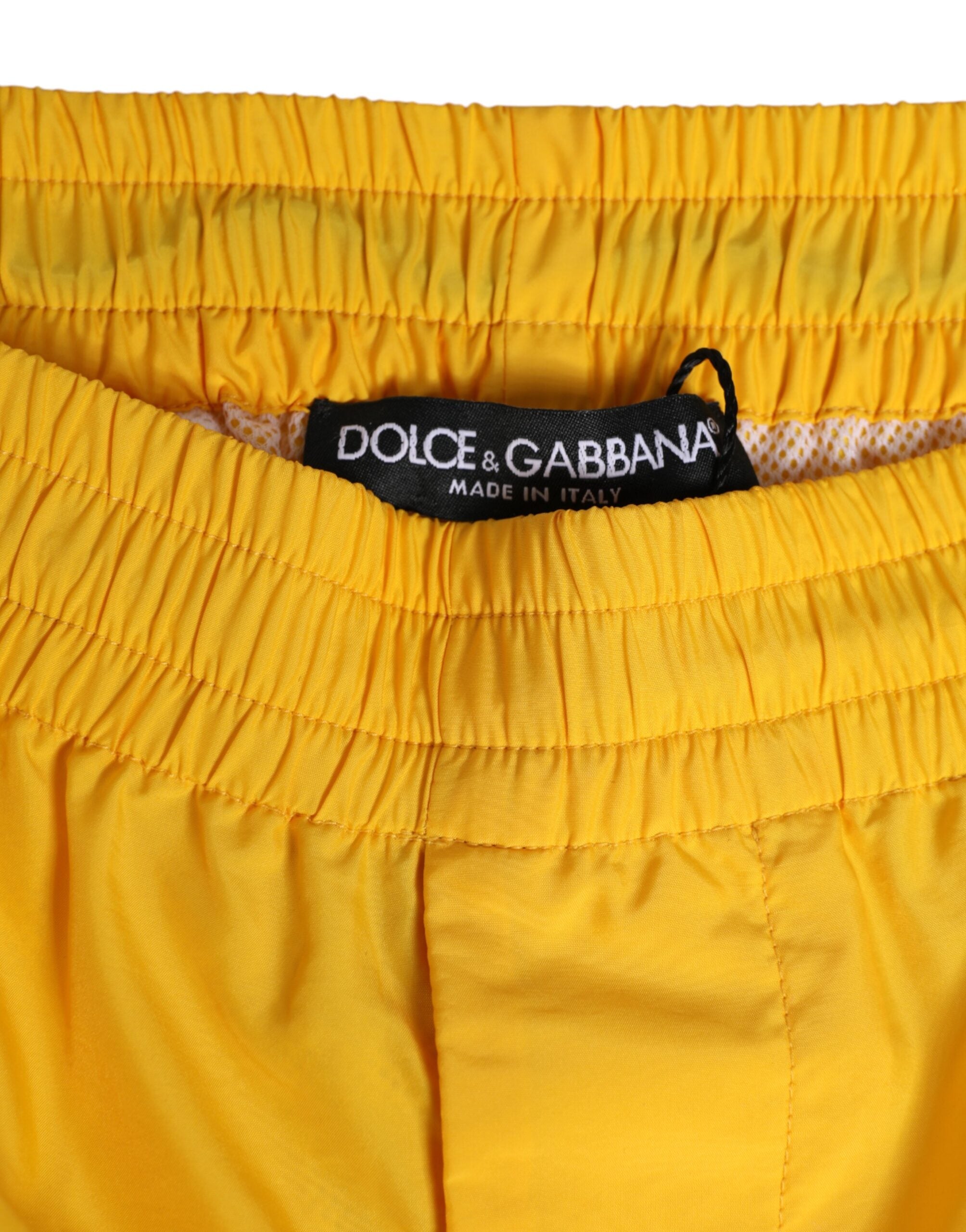 Boxers de bain en nylon jaune Dolce & Gabbana avec logo et plaque de marque, détails visibles sur le maillot de bain.