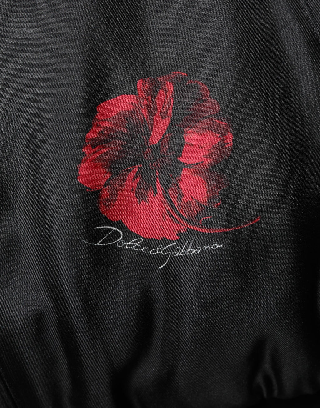Veste bomber en soie noire et rouge à fleurs Dolce & Gabbana, style élégant avec motif floral et finition raffinée.