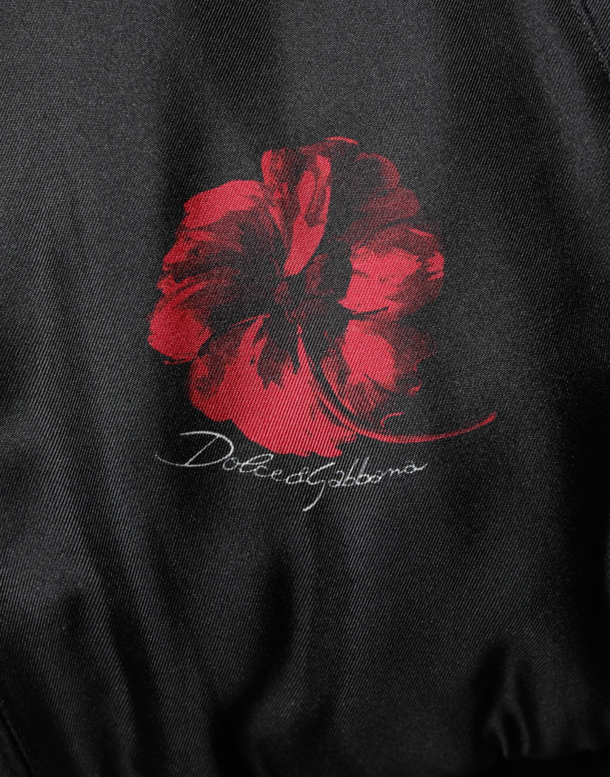 Veste bomber en soie noire et rouge à fleurs Dolce & Gabbana, style élégant avec motif floral et finition raffinée.