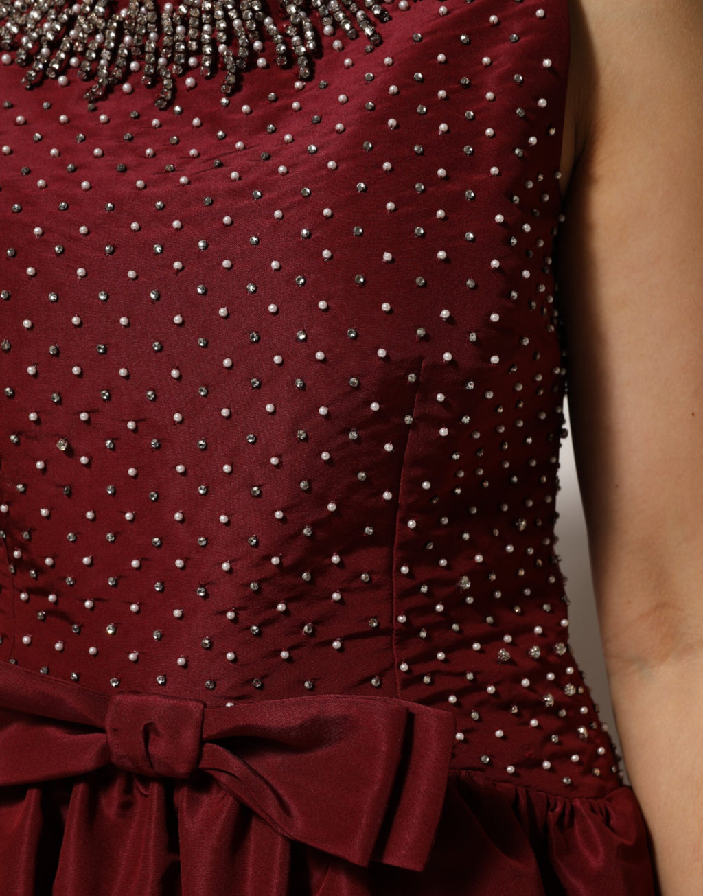 Robe de soirée en soie bordeaux avec perles, Dolce & Gabbana, élégante et sophistiquée, portée pour une occasion spéciale.