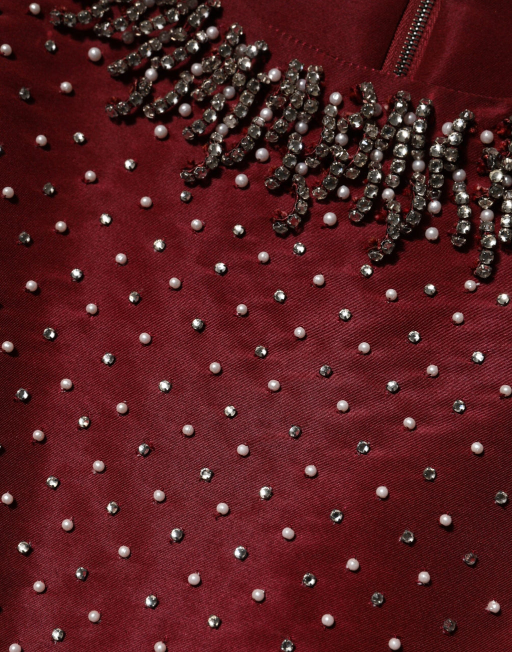 Robe de soirée en soie bordeaux avec perles, conçue par Dolce & Gabbana, élégante et ornée de détails sophistiqués.
