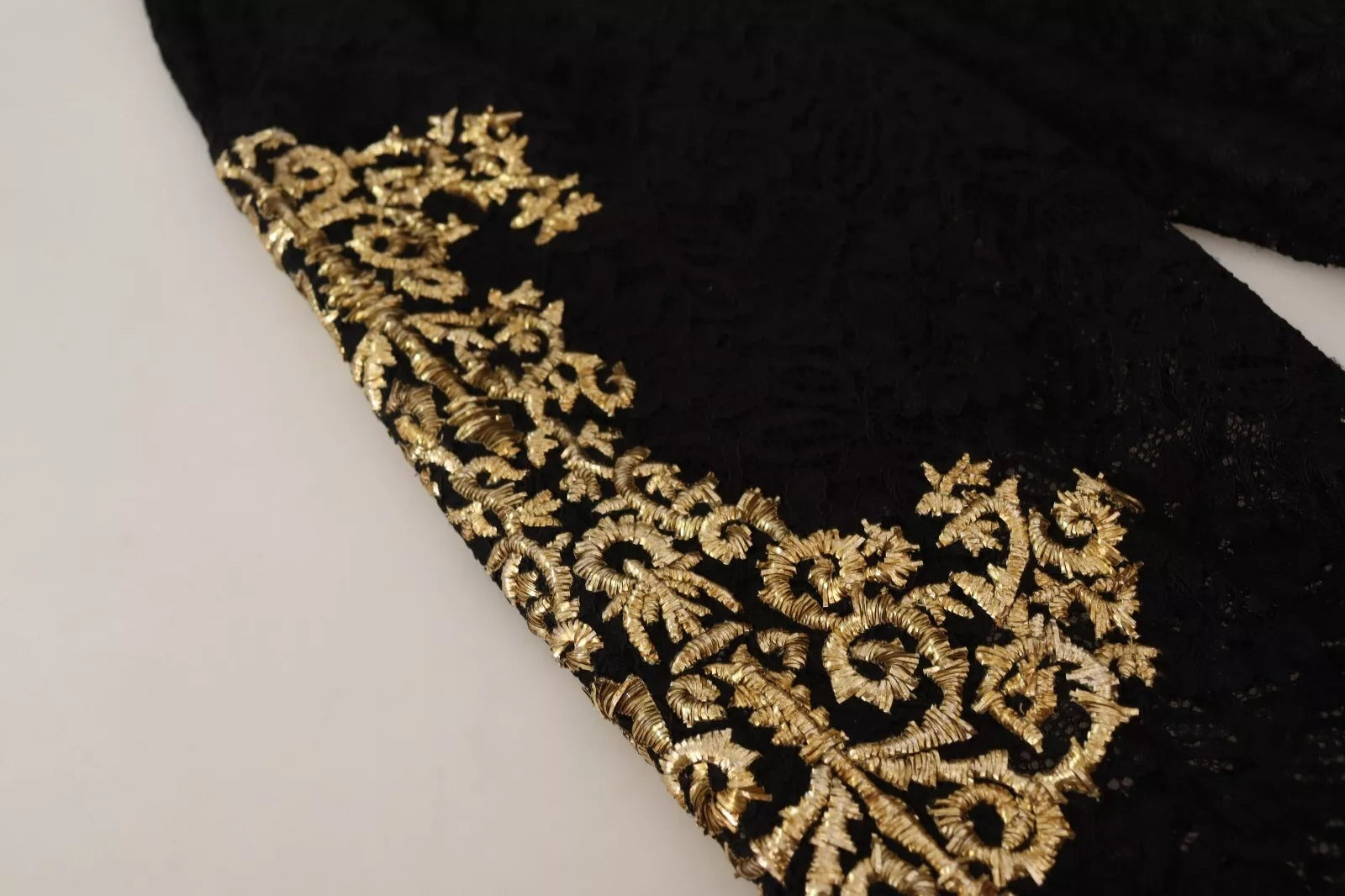 Shorts Dolce & Gabbana en dentelle noire avec détails dorés style baroque, pièce spéciale élégante.