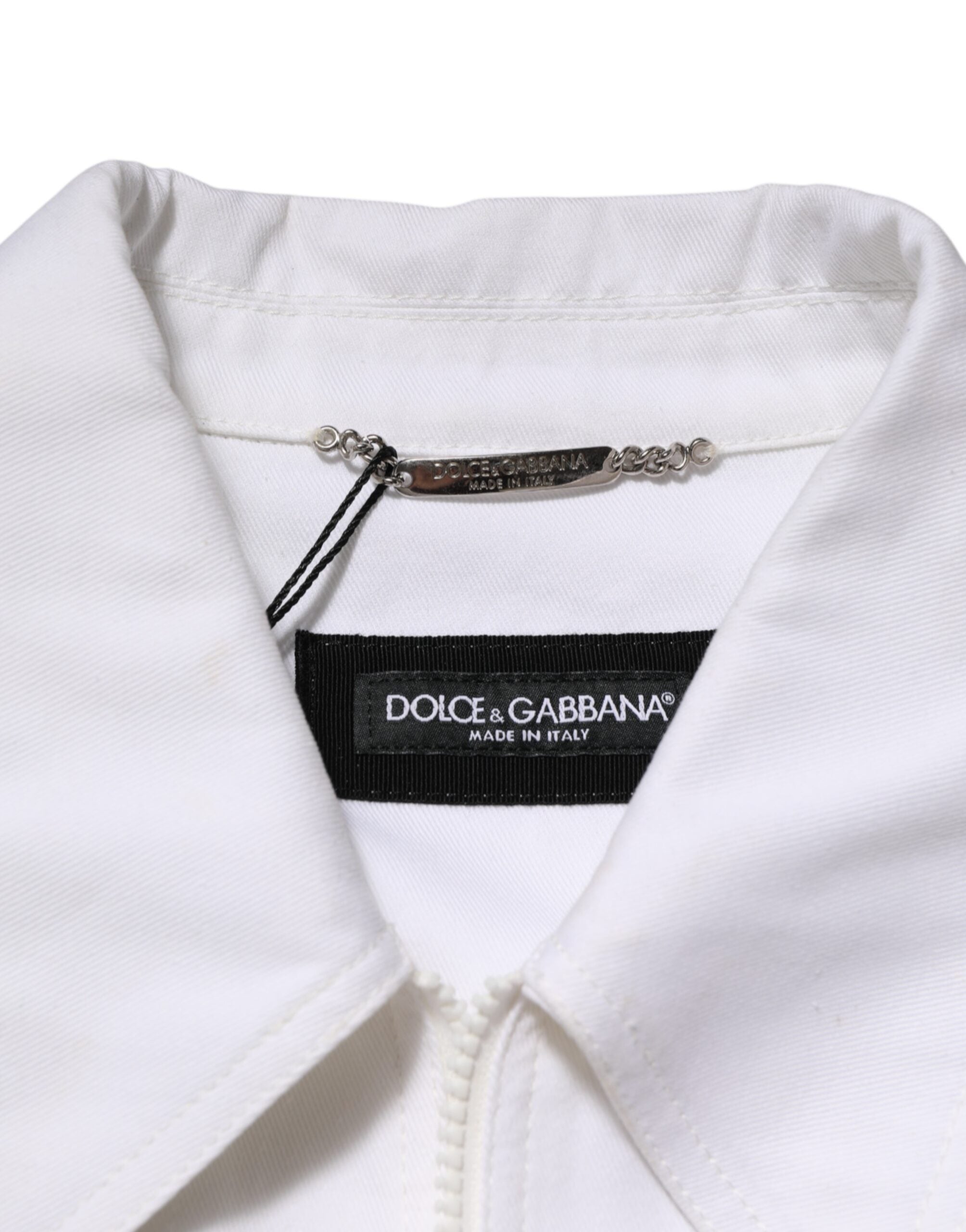 Combinaison blanche Dolce & Gabbana avec patch barrière, zip utilitaire, pantalon élégant et moderne, détails de mode tendance.