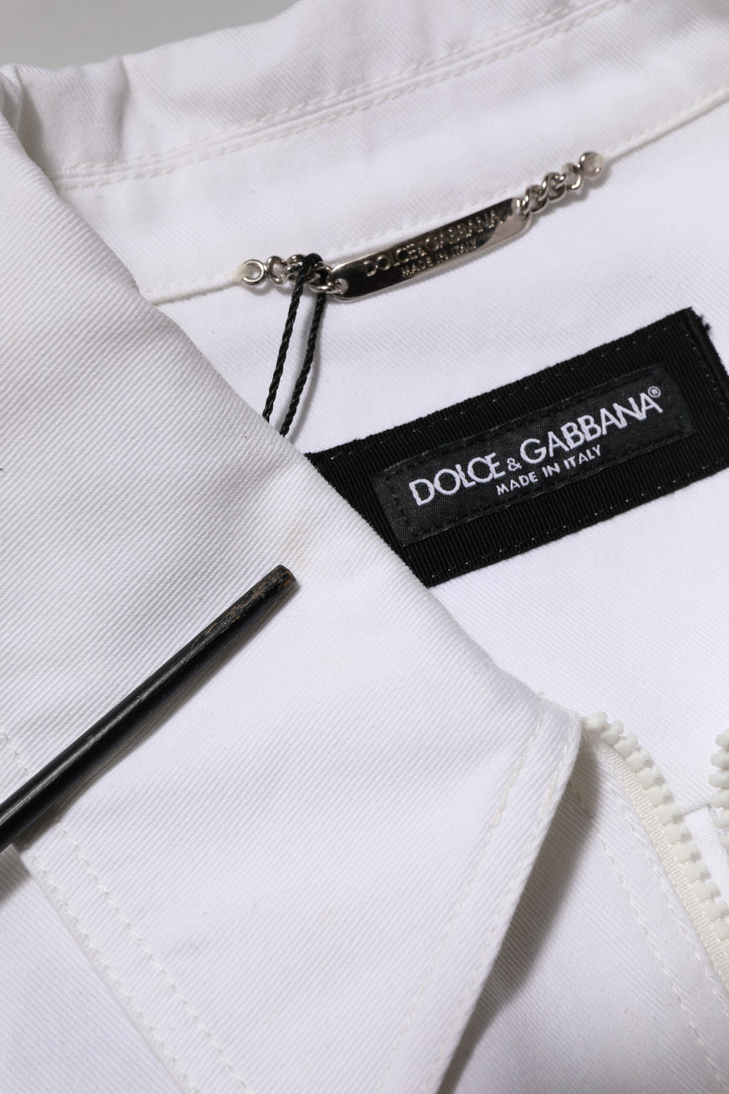 Combinaison blanche Dolce & Gabbana avec patch barcode, zip utilitaire, pantalon ajusté, style moderne et tendance.