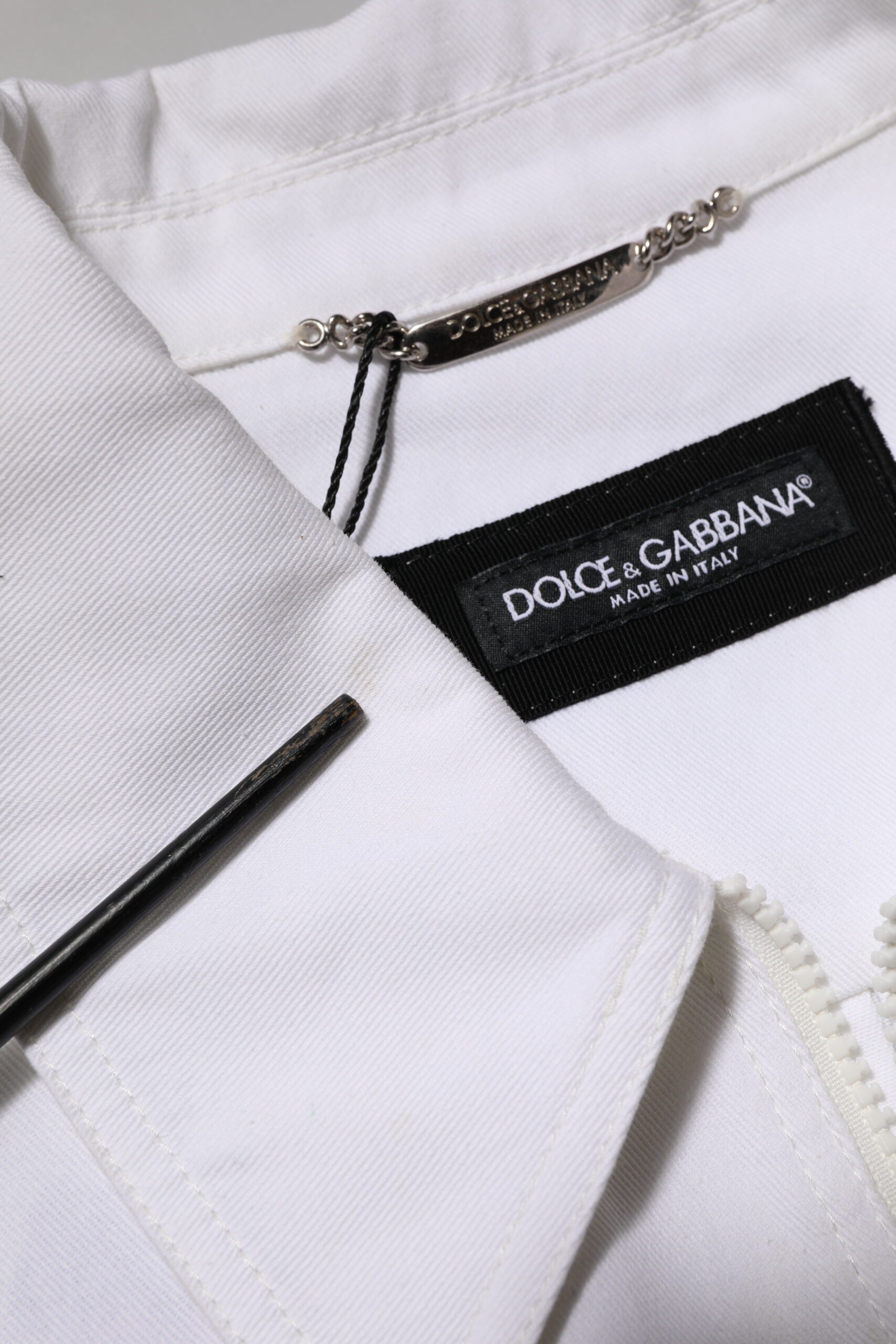 Combinaison blanche Dolce & Gabbana avec patch barcode, zip utilitaire, pantalon ajusté, style moderne et tendance.