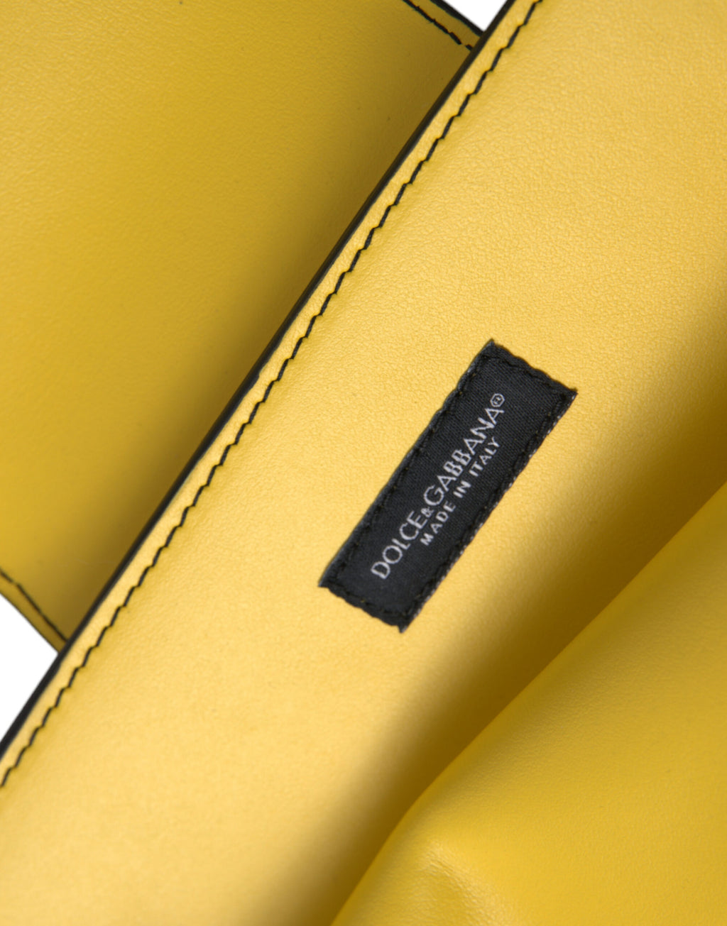 Sac clutch Dolce & Gabbana en cuir jaune lisse avec logo DG, porté en bandoulière, style élégant et sophistiqué.