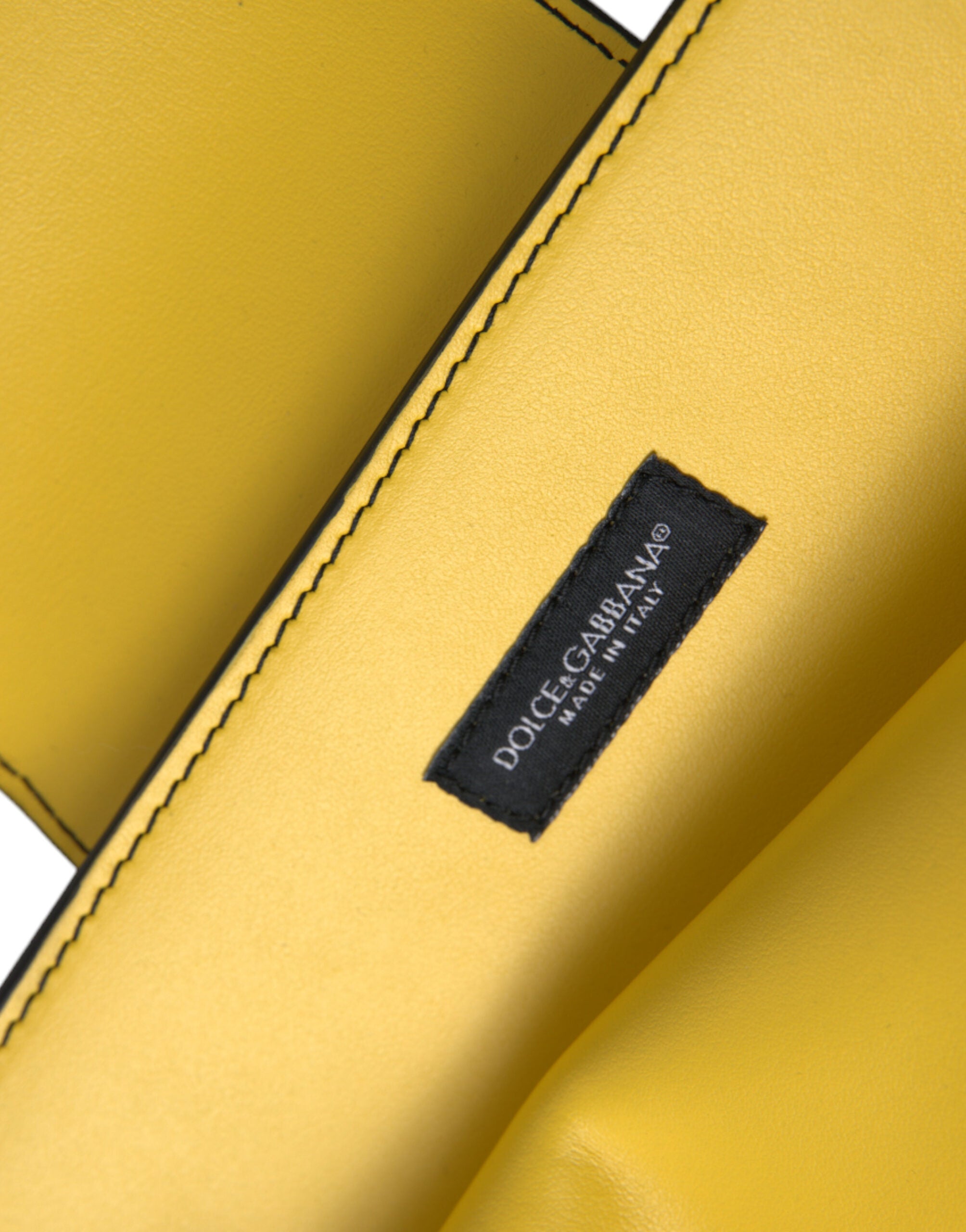 Sac clutch Dolce & Gabbana en cuir jaune lisse avec logo DG, porté en bandoulière, style élégant et sophistiqué.