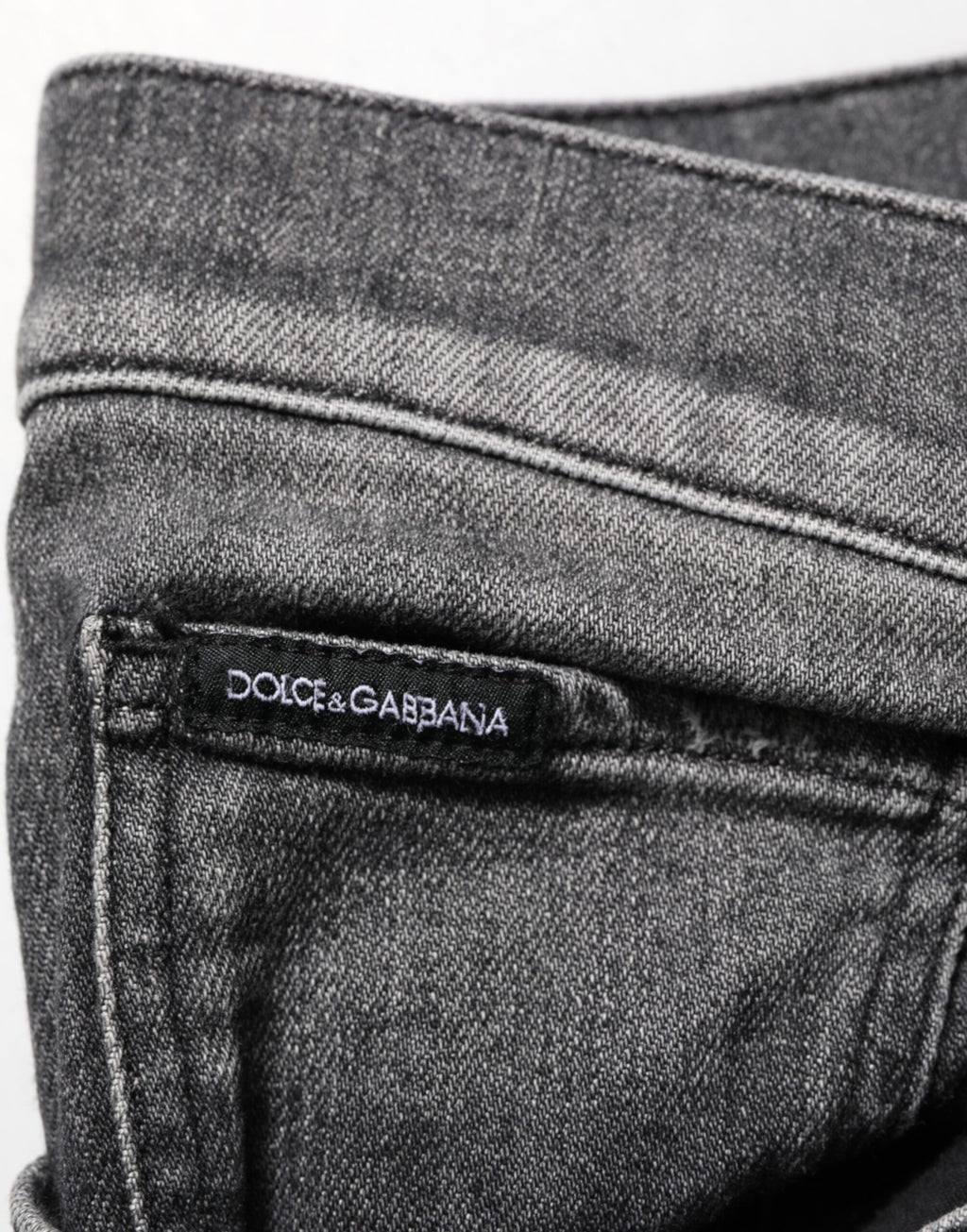 Jeans slim droit Dolce & Gabbana en denim noir et gris, coupe ajustée, visible sur le modèle.