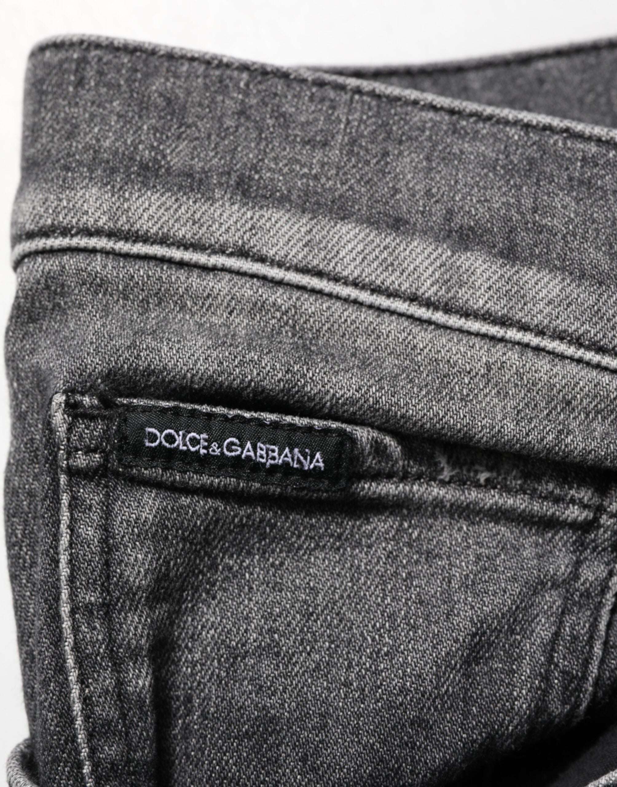 Jeans slim droit Dolce & Gabbana en denim noir et gris, coupe ajustée, visible sur le modèle.