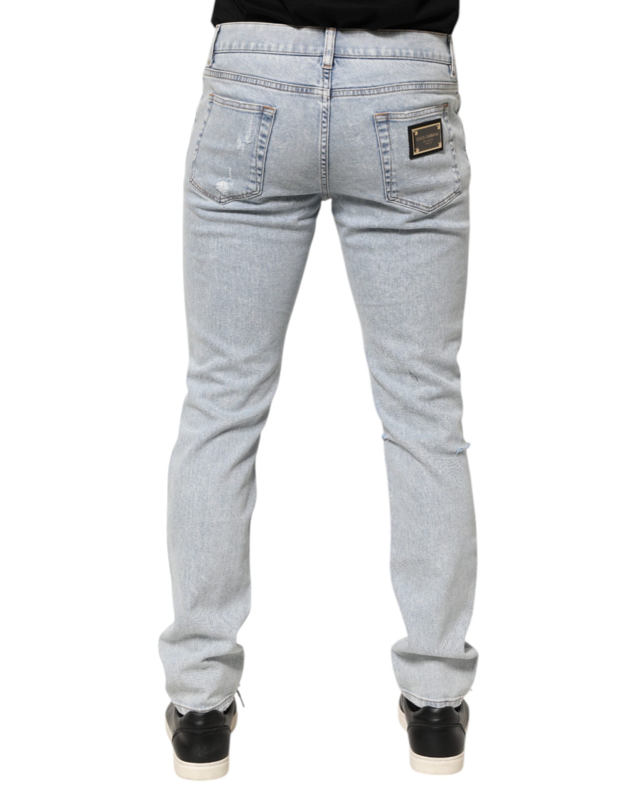 Jeans slim déchirés Dolce & Gabbana Light Blue, denim clair, coupe ajustée, avec détails effilochés et usés.
