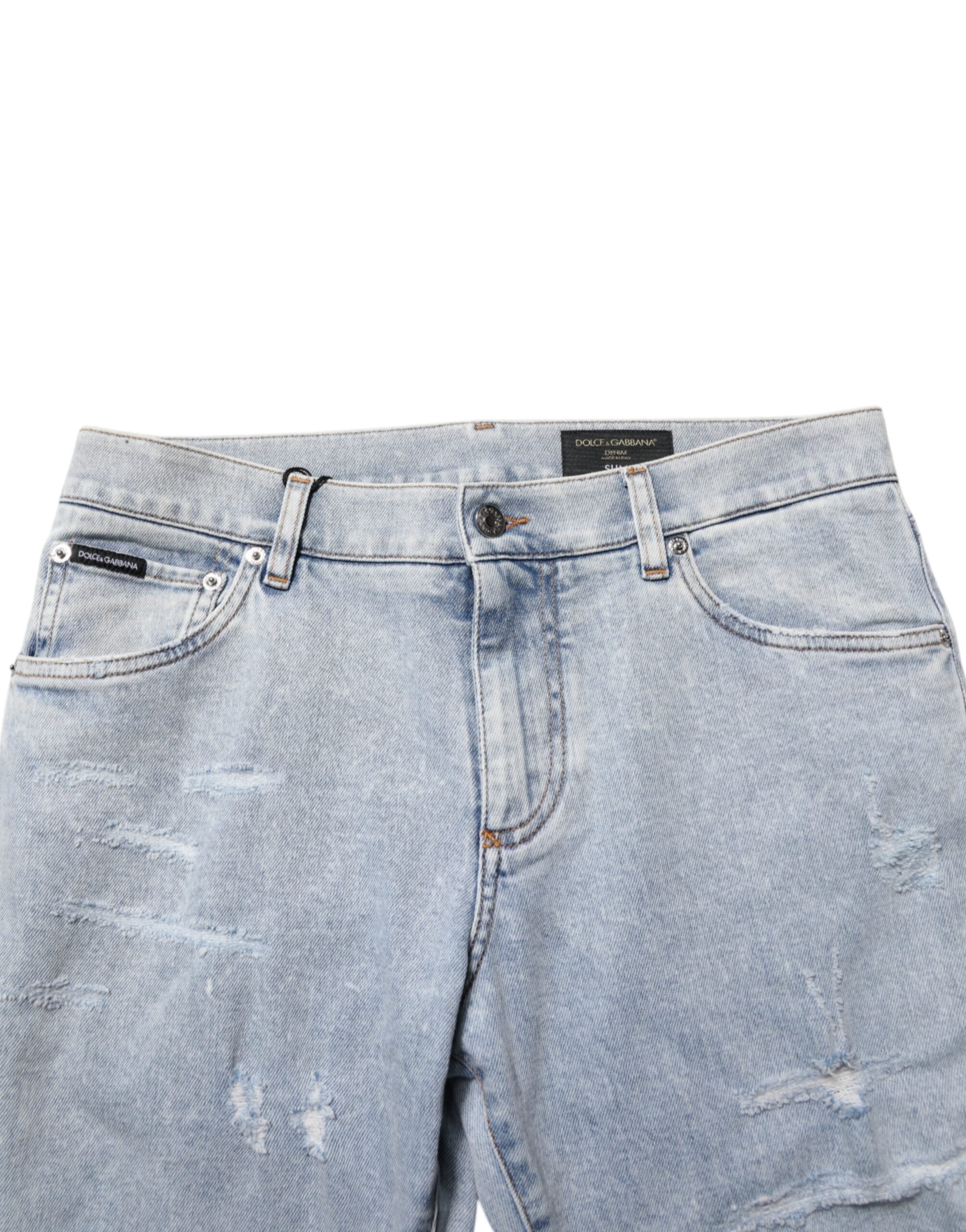 Jeans slim déchirés Dolce & Gabbana Light Blue en denim distressed avec coupe ajustée, visibles sur l'image.