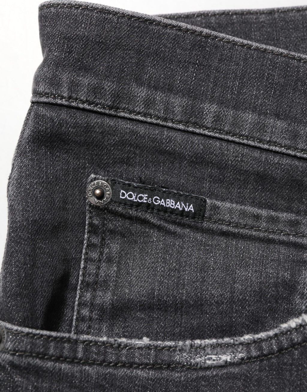 Jeans slim en coton noir Dolce & Gabbana avec déchirures, logo en relief et style décontracté.