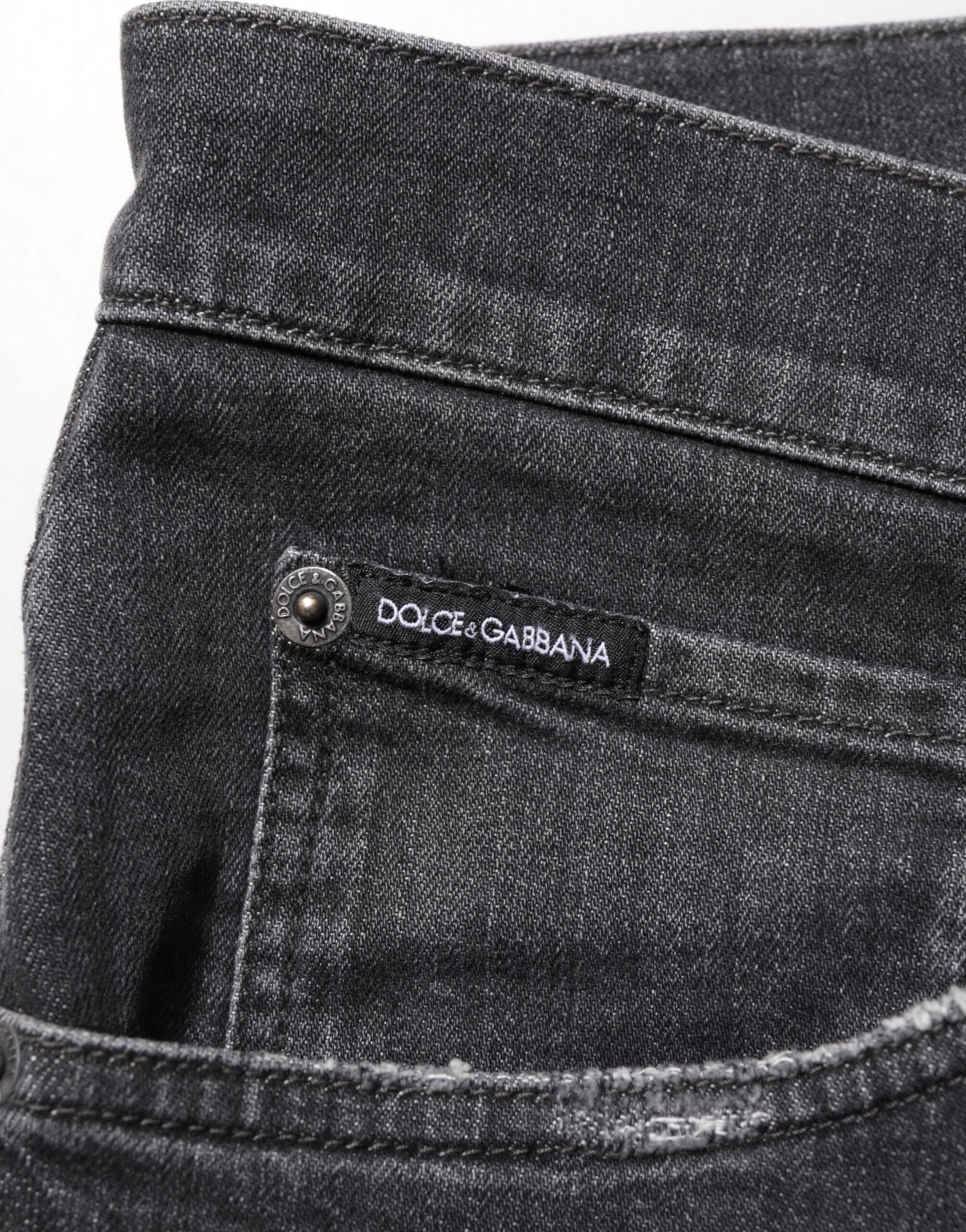 Jeans slim en coton noir Dolce & Gabbana avec déchirures, logo en relief et style décontracté.
