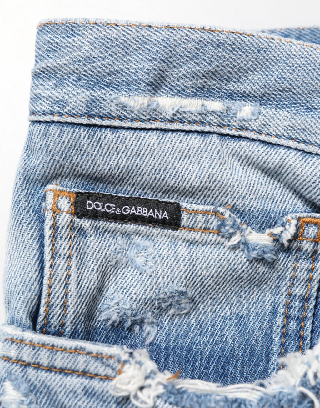 Jeans en denim bleu déchiré Dolce & Gabbana avec détails usés et style décontracté, visibles sur l'image.