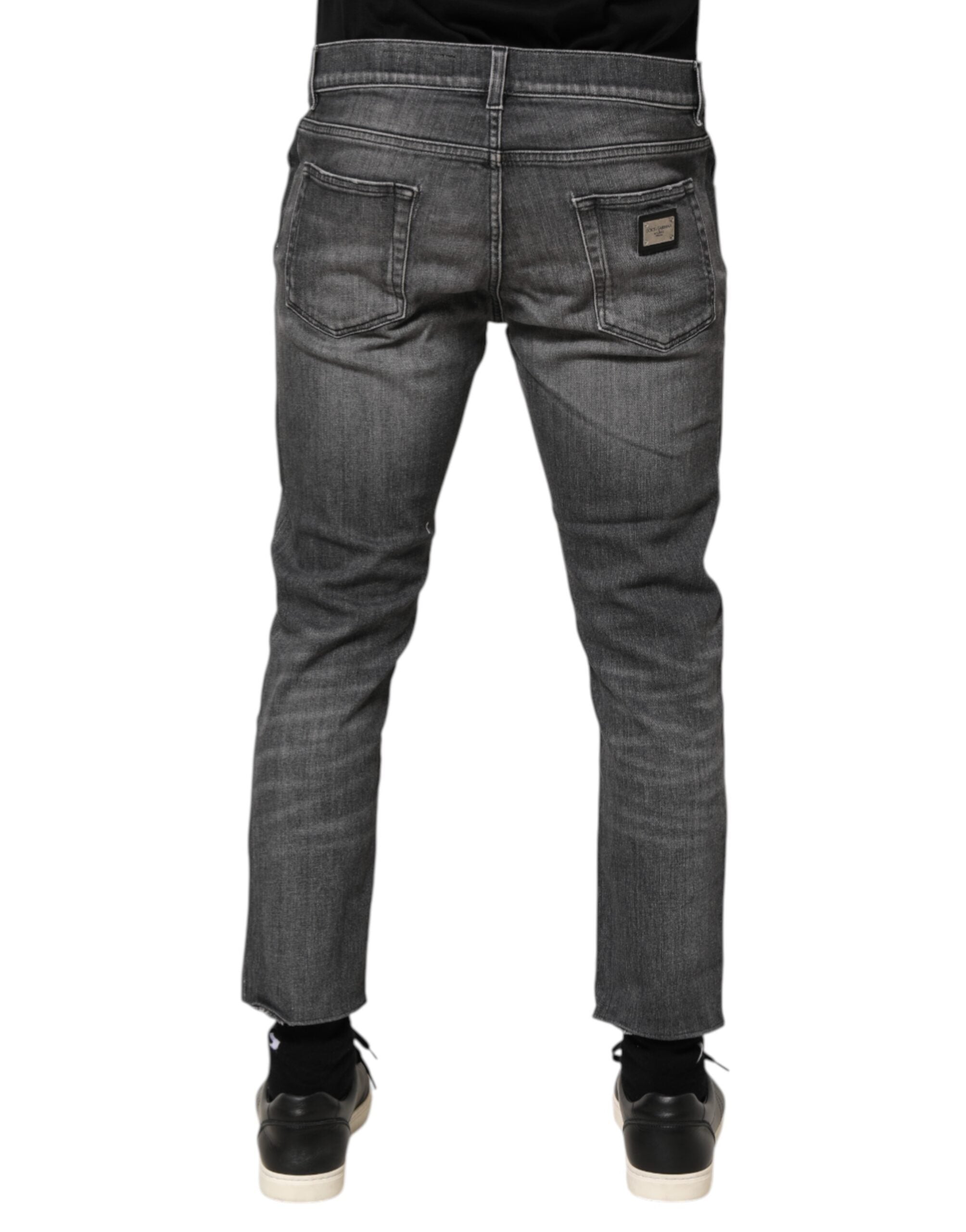 Jeans slim en denim gris en coton de Dolce & Gabbana avec détails déchirés et style ajusté, visibles sur l'image.