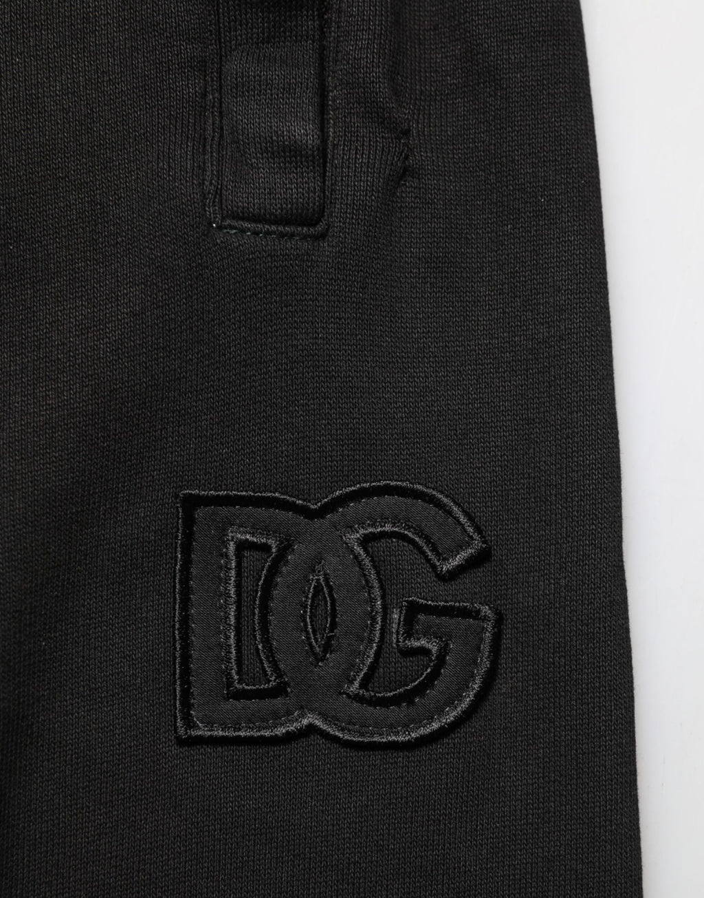Pantalon jogger homme Dolce & Gabbana en coton noir avec logo DG, décontracté et confortable, vue de face sur un mannequin.