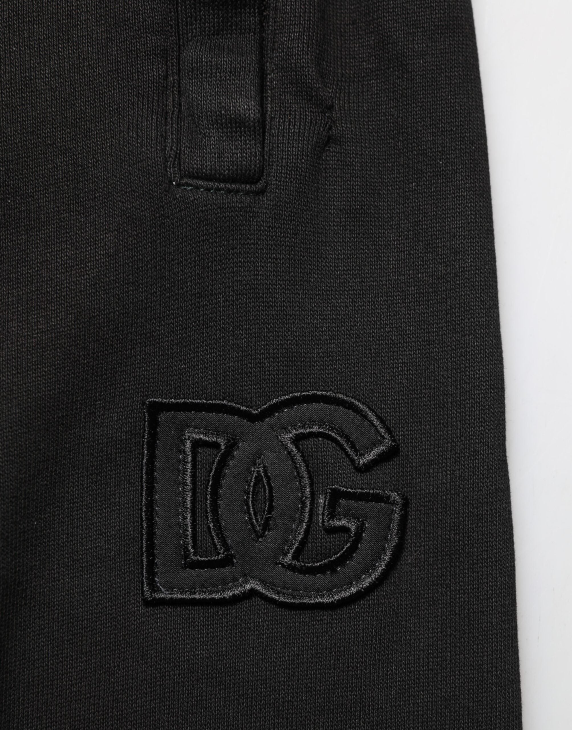 Pantalon jogger homme Dolce & Gabbana en coton noir avec logo DG, décontracté et confortable, vue de face sur un mannequin.