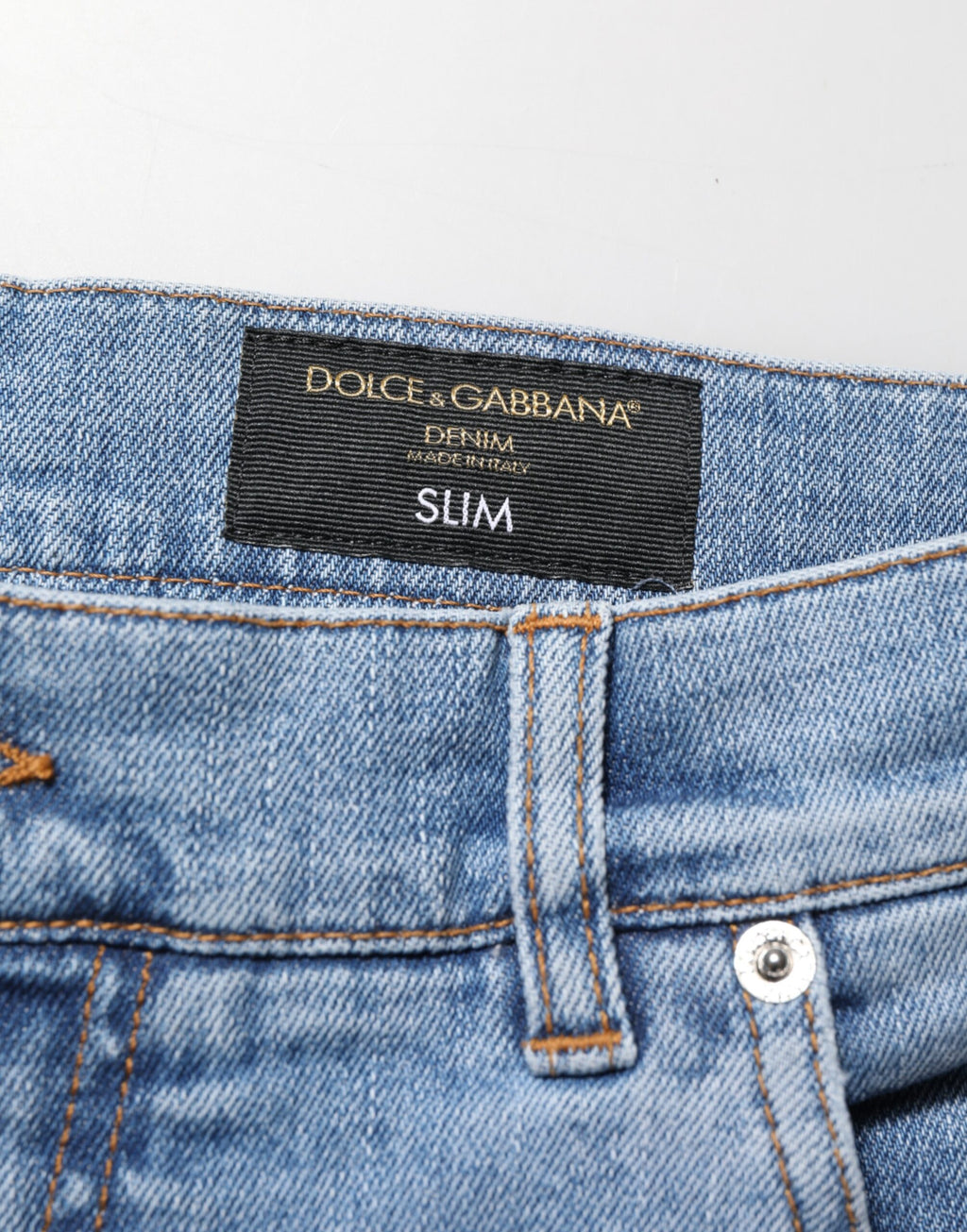 Jeans en denim coton bleu déchiré, coupe slim, de la marque Dolce & Gabbana, visibles avec détails déchirés et finition élégante.