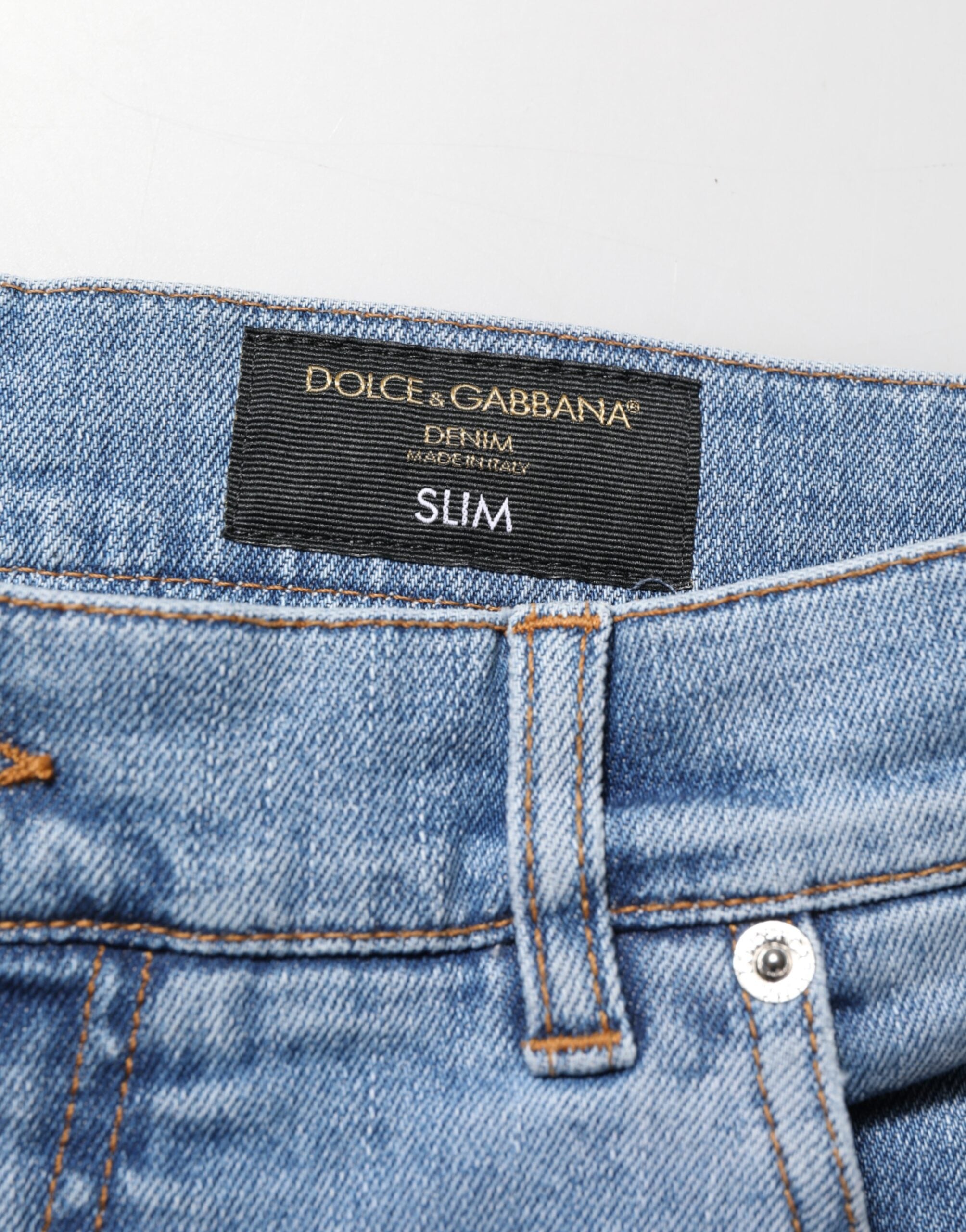 Jeans en denim coton bleu déchiré, coupe slim, de la marque Dolce & Gabbana, visibles avec détails déchirés et finition élégante.