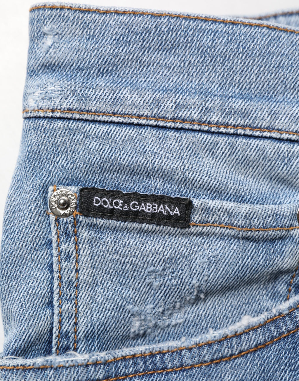 Jeans en denim bleu tattered Dolce & Gabbana, coupe slim fit en coton, visible avec déchirures et détails usés.
