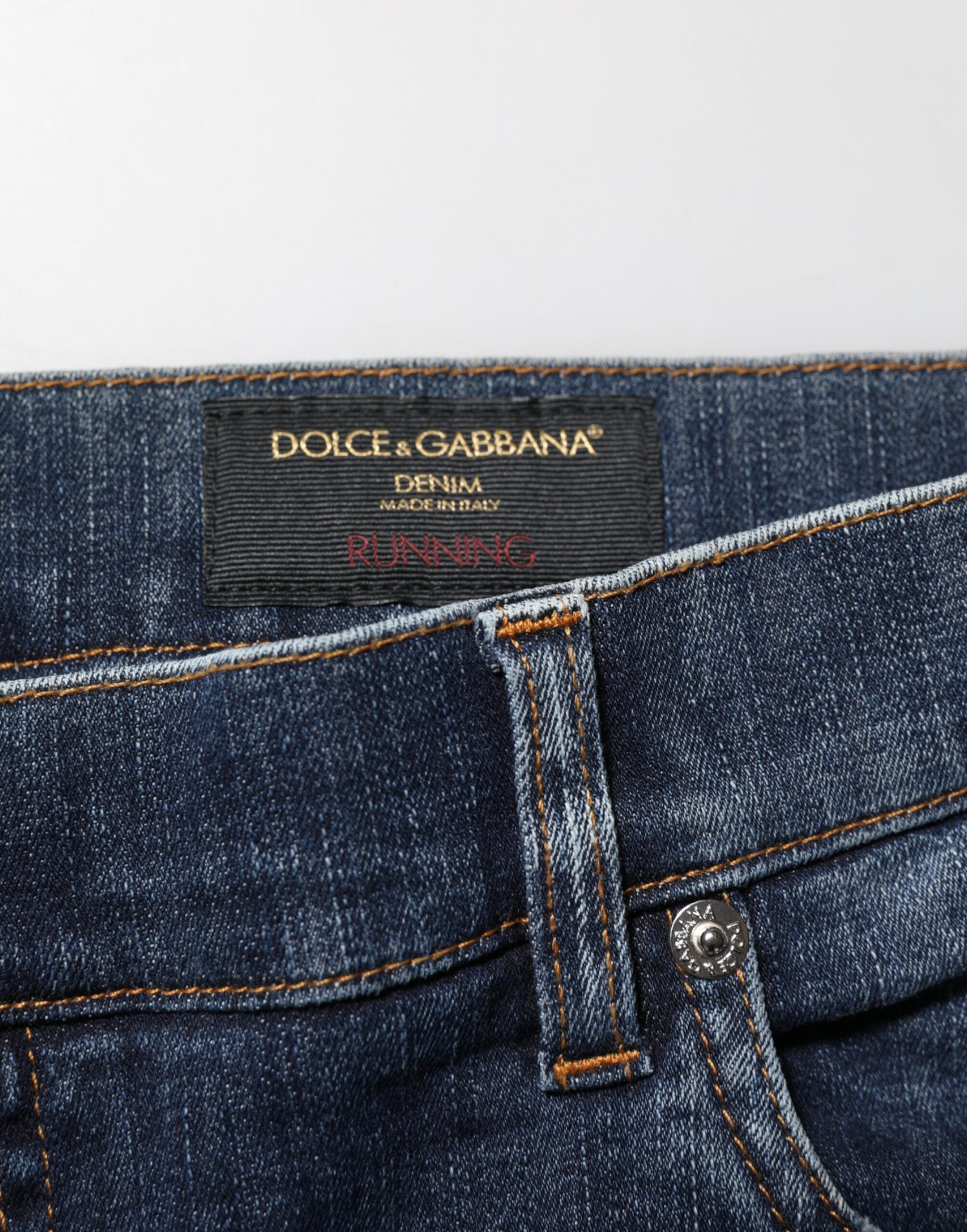 Jeans déchirés en denim bleu foncé Dolce & Gabbana, style délavé et coupe décontractée, visibles sur l'image.
