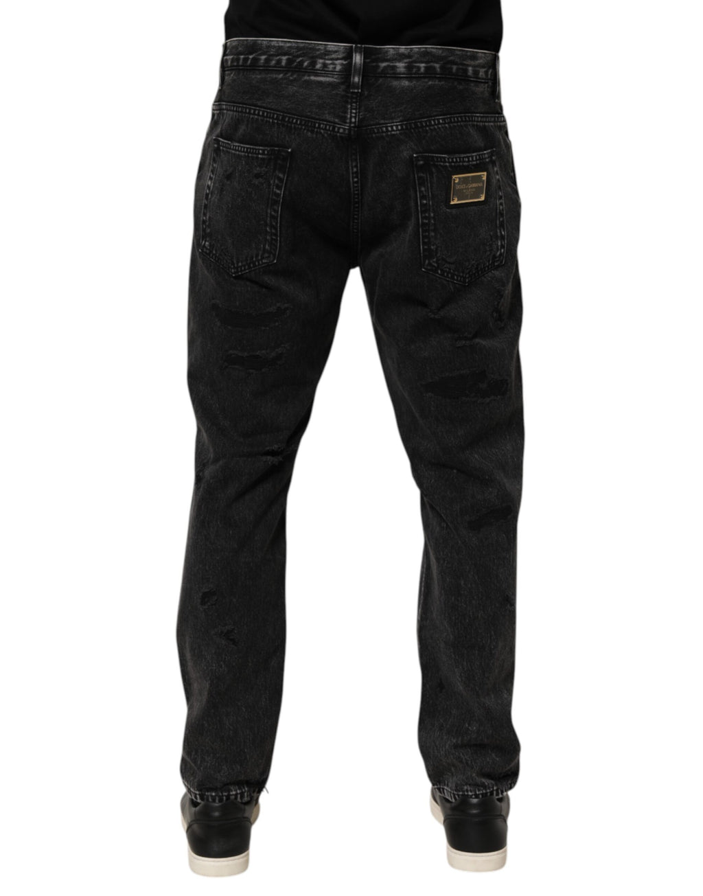 Jeans en denim coton délavé noir Dolce & Gabbana avec déchirures et coupe lâche, visible en gros plan.