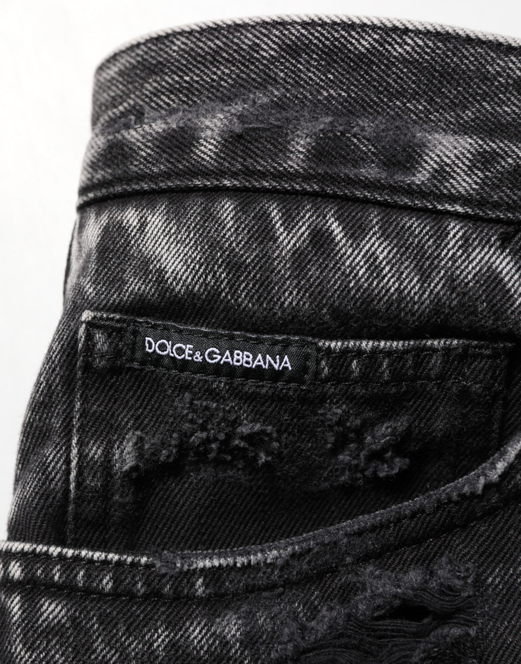 Jeans en denim coton délavé noir de Dolce & Gabbana, déchirés et amples, avec un style décontracté et moderne.