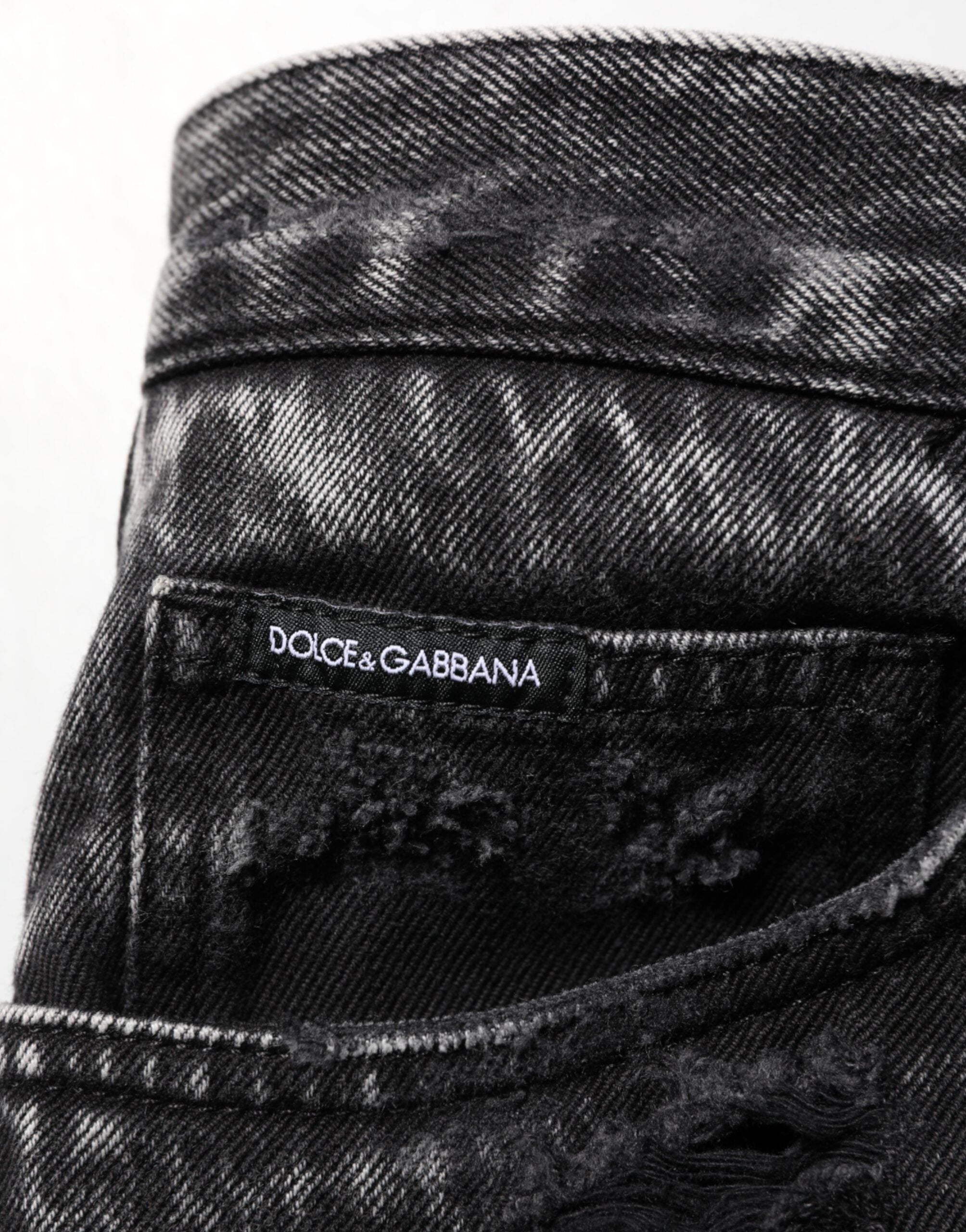 Jeans en denim coton délavé noir de Dolce & Gabbana, déchirés et amples, avec un style décontracté et moderne.