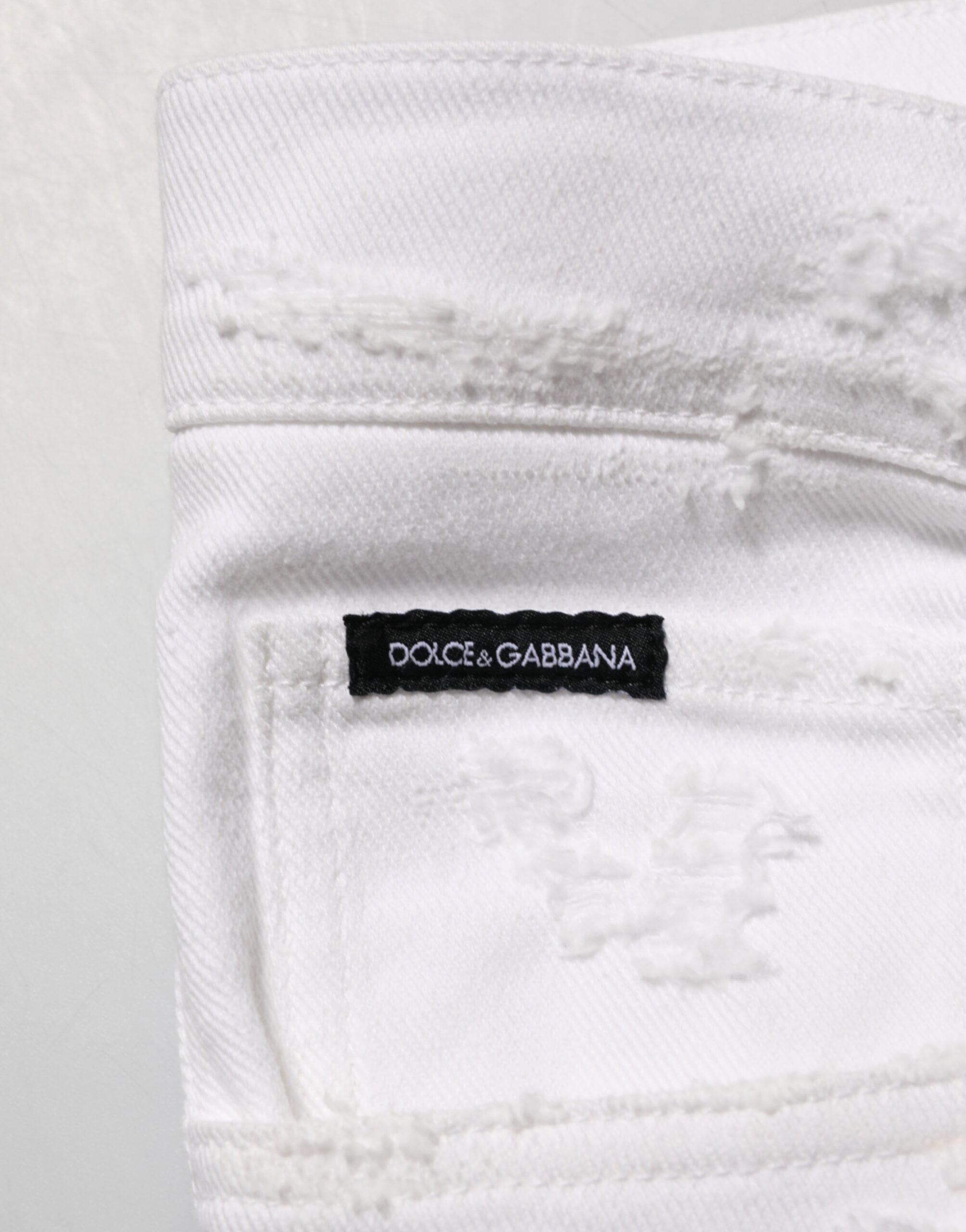 Jeans Dolce & Gabbana blanc déchiré et délavé en denim distressed avec coupe décontractée.