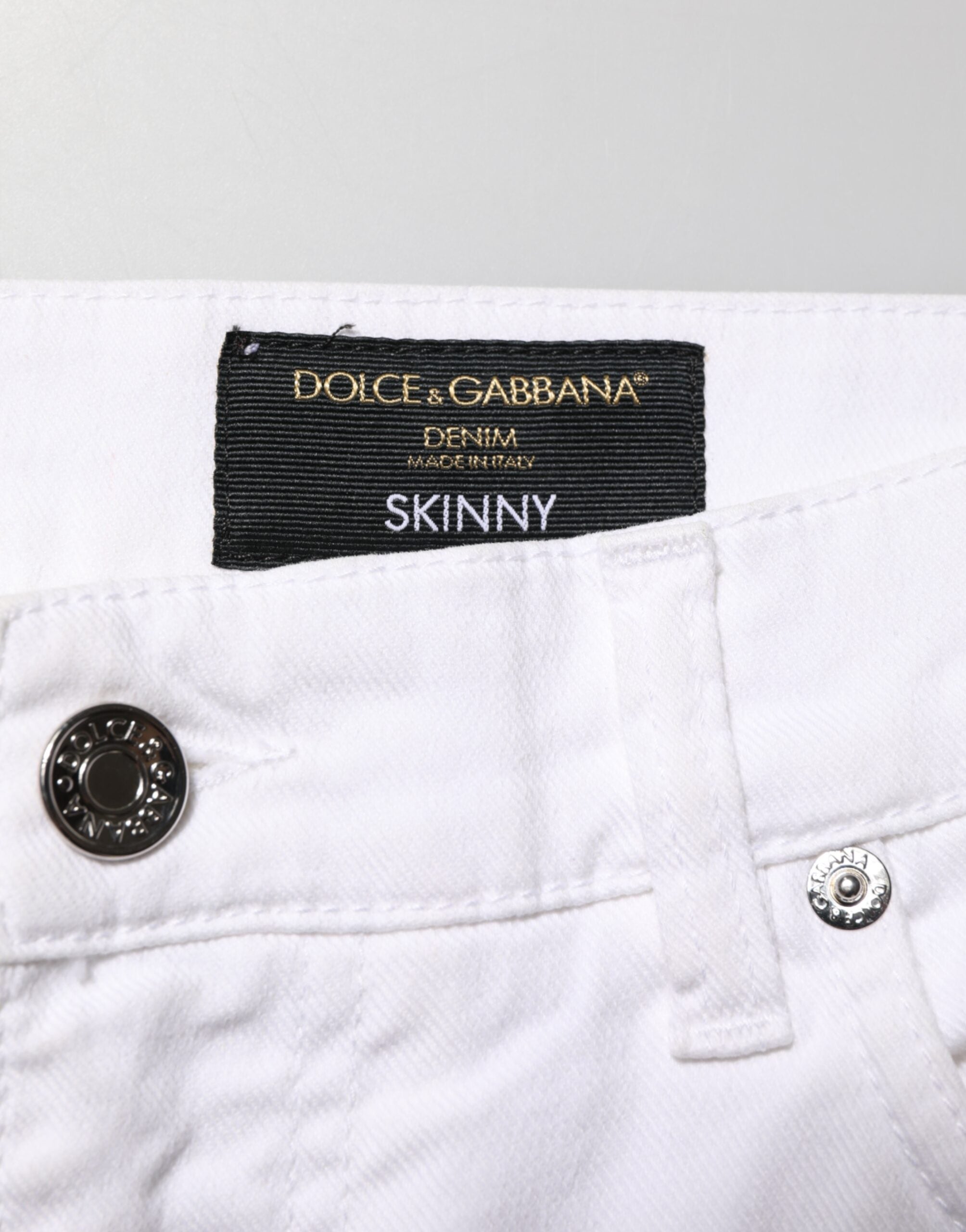 Jeans skinny en denim blanc Dolce & Gabbana avec déchirures pour homme, coupe ajustée et style décontracté.
