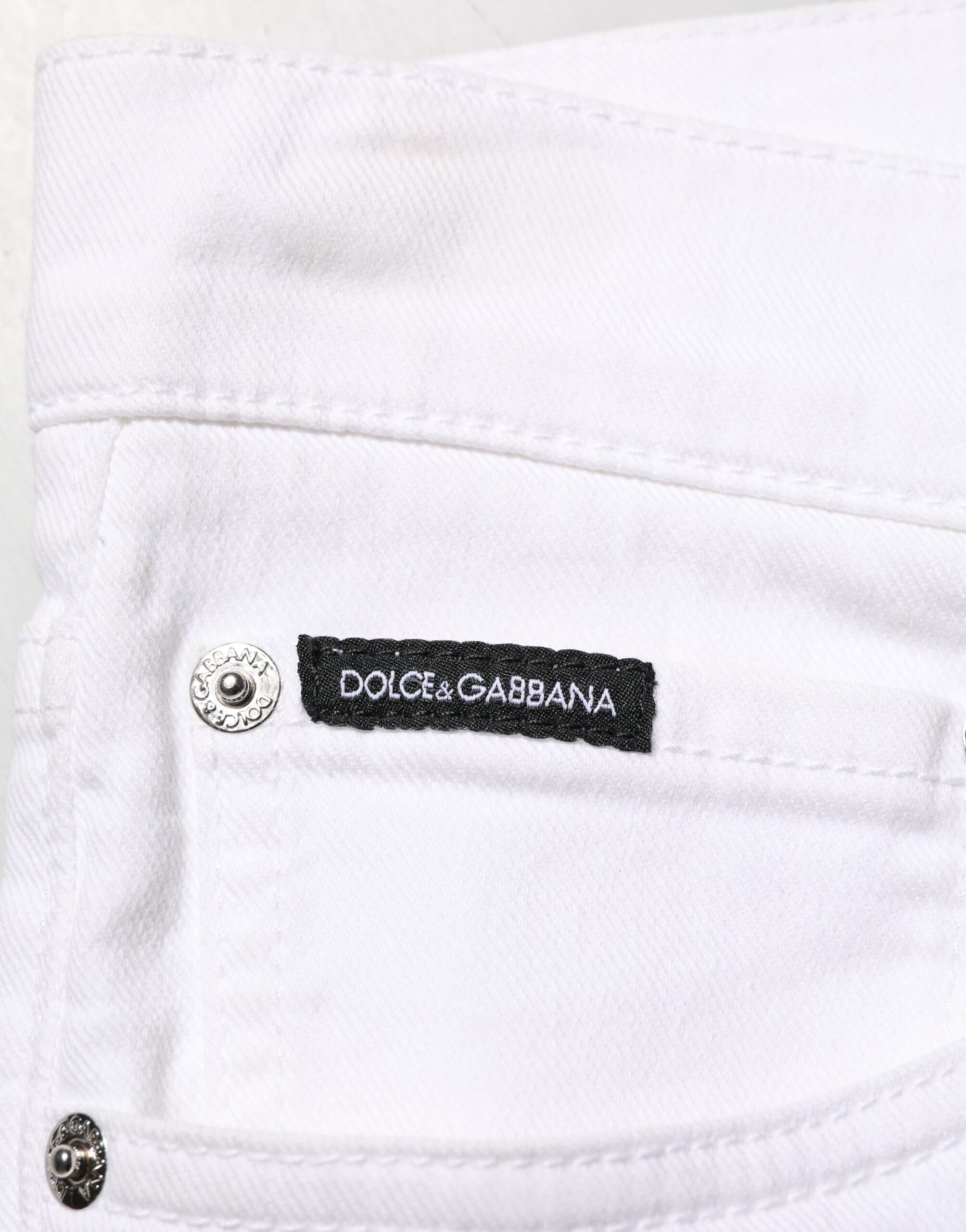 Jeans slim déchirés en coton blanc de Dolce & Gabbana pour homme, denim skinny avec détails usés.