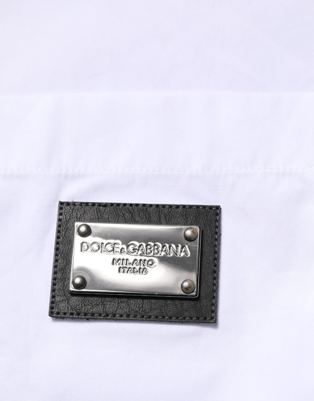 Chemise formelle blanche Dolce & Gabbana avec logo, col élégant et plaque de marque visible.