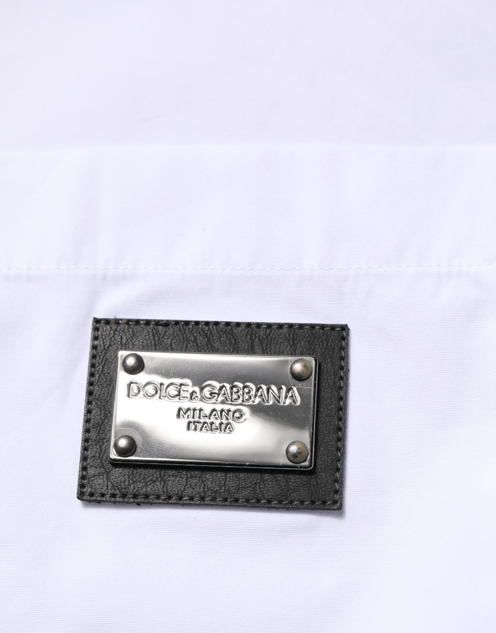 Chemise formelle blanche Dolce & Gabbana avec logo, col élégant et plaque de marque visible.