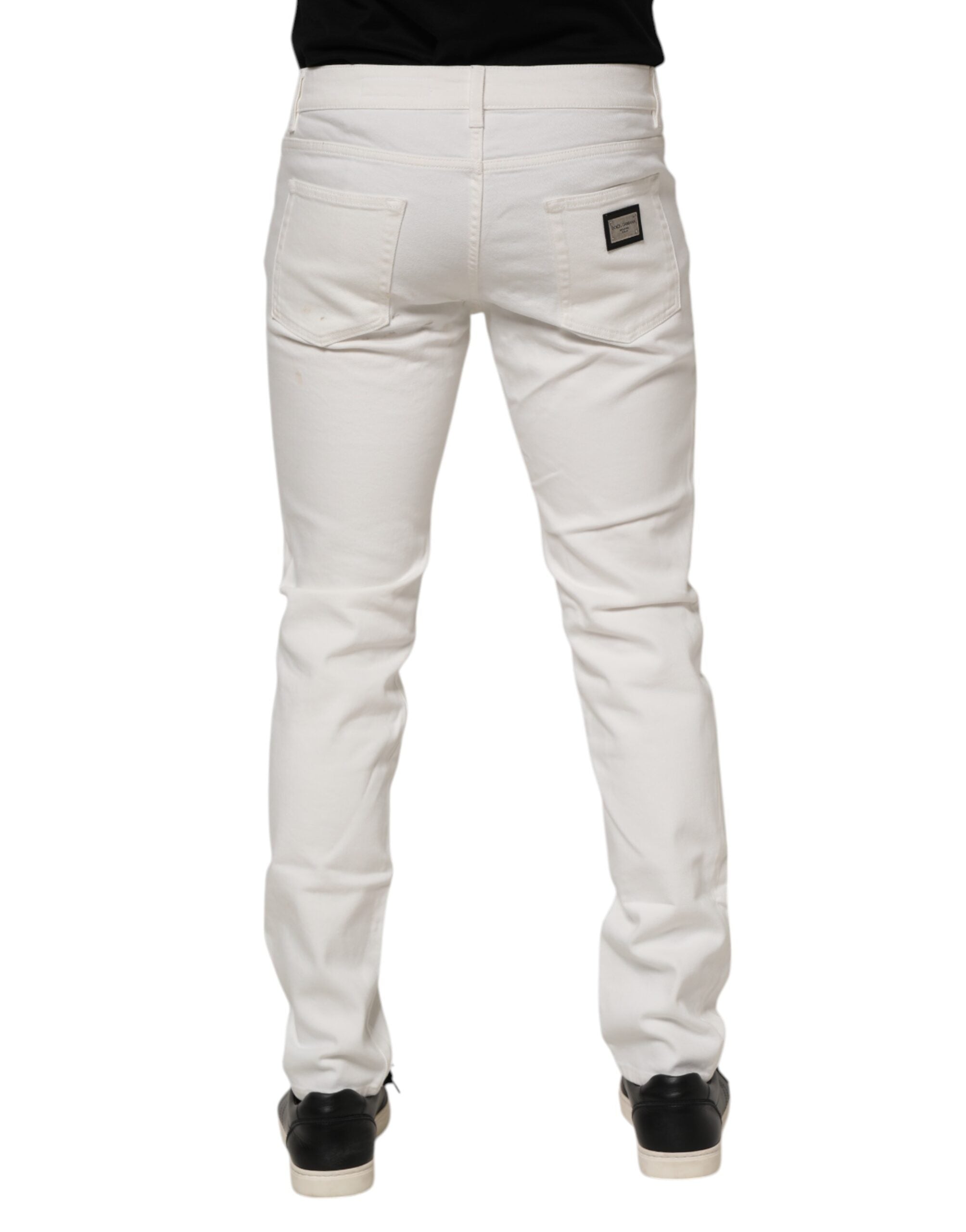 Jeans slim en coton stretch blanc cassé de Dolce & Gabbana, coupe ajustée et élégante, visibles sur l'image.